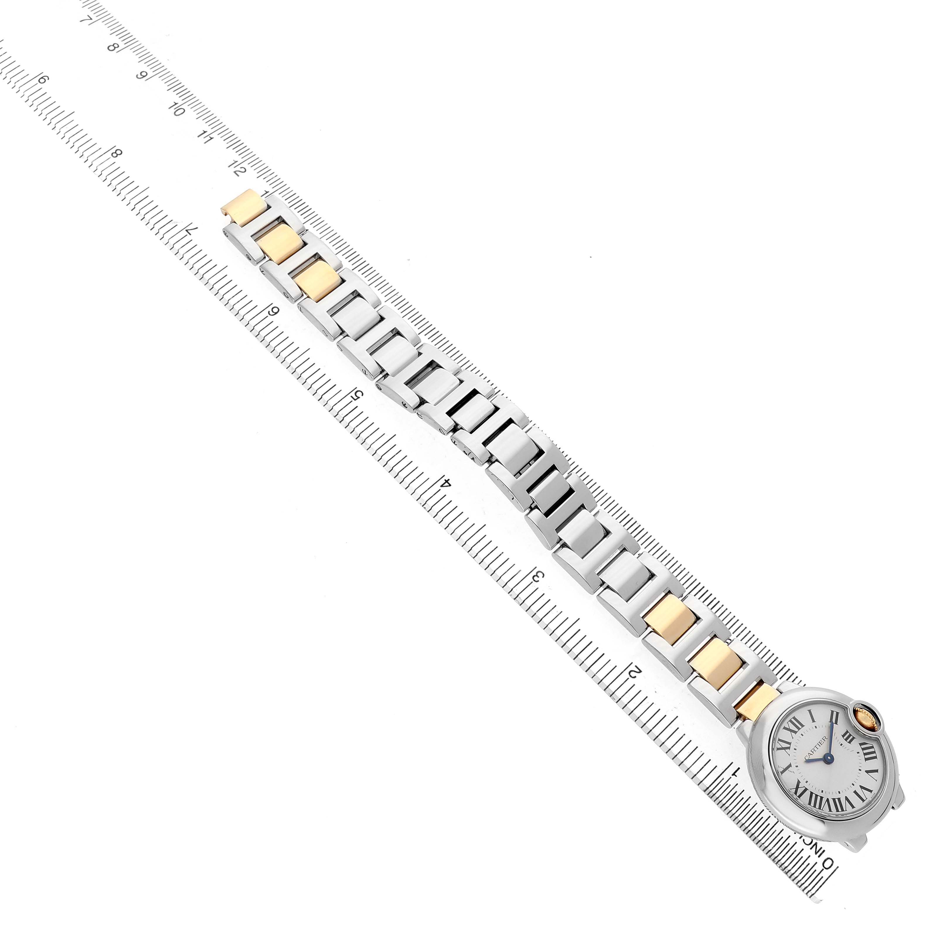 The Cartier Ballon Bleu W69007Z3 Women's Steel and Gold (two tone) Silver Dial watch is shown from a top view, highlighting the face and two-tone metal bracelet alongside a ruler.