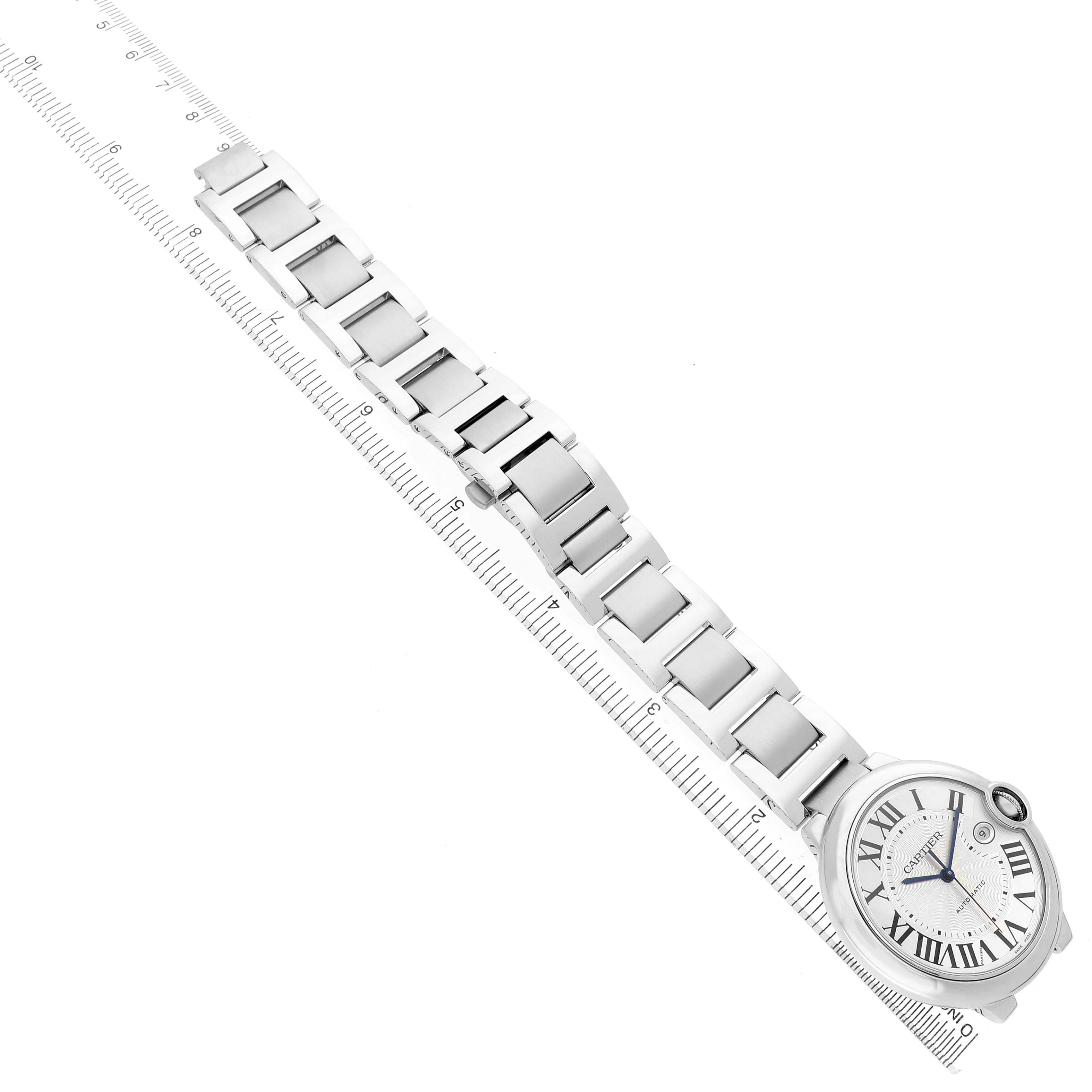 The Cartier Ballon Bleu W69012Z4 Men's Stainless Steel Silver Dial watch is shown from an overhead angle, highlighting the face and bracelet alongside a ruler for scale.