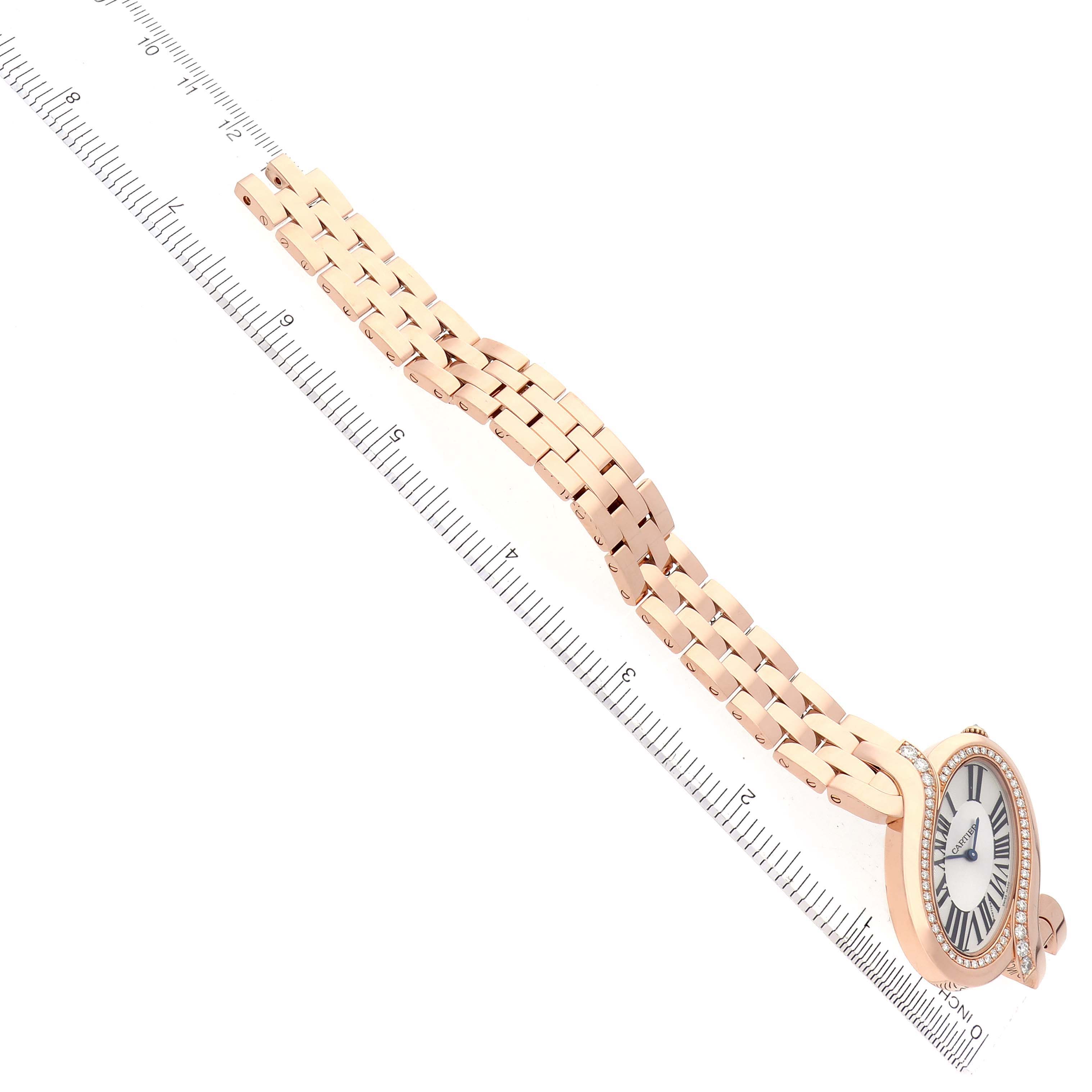 The Cartier Delices WG800006 Women
s Rose Gold Silver Dial WG800006 Women
s Rose Gold Silver Dial watch is shown from an angled top view, highlighting the face, case, and bracelet against a ruler for scale.