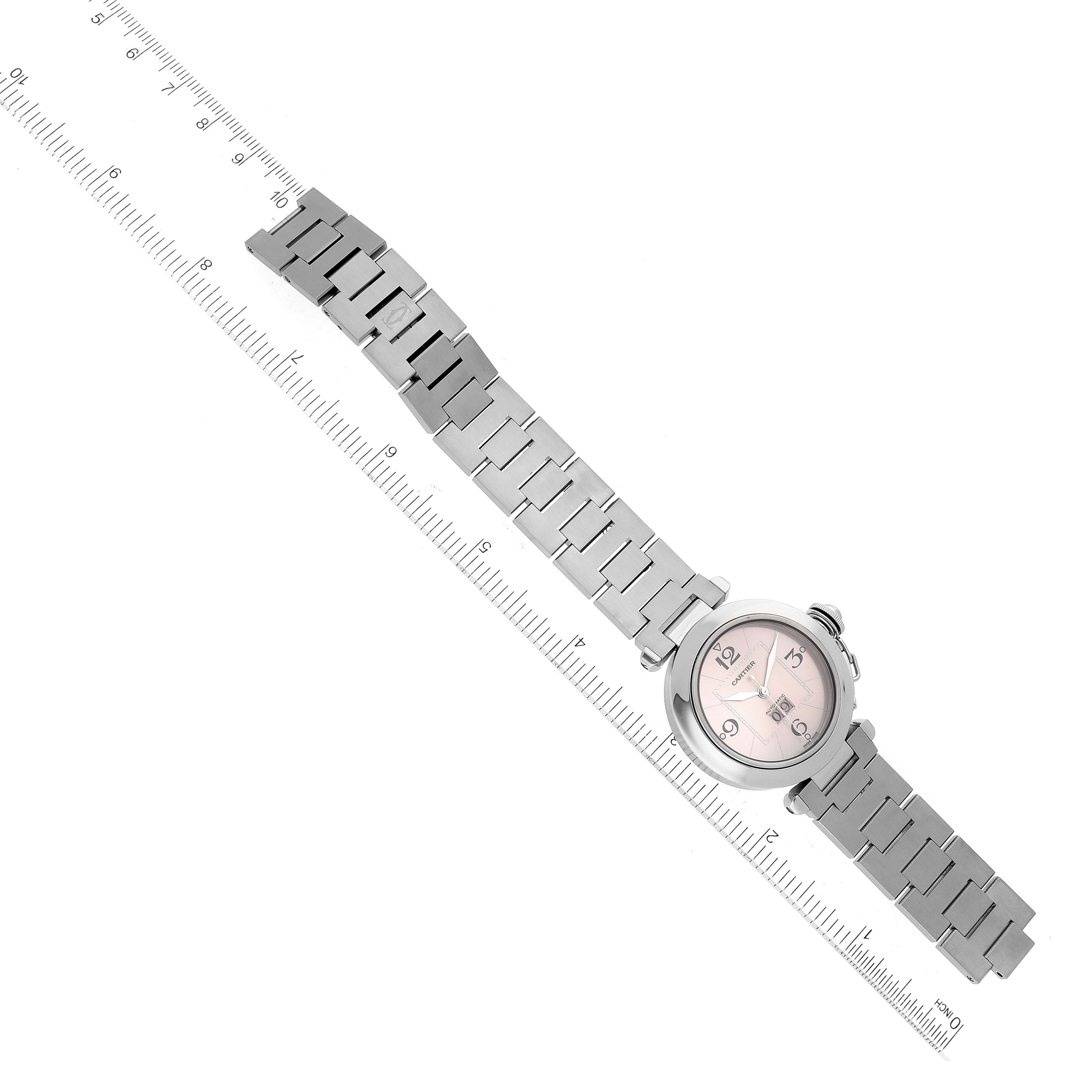 The image shows an overhead view of a Cartier Pasha W31058M7 Women's Stainless Steel Pink Dial W31058M7 Women's Stainless Steel Pink Dial watch, displaying its face and metal bracelet.