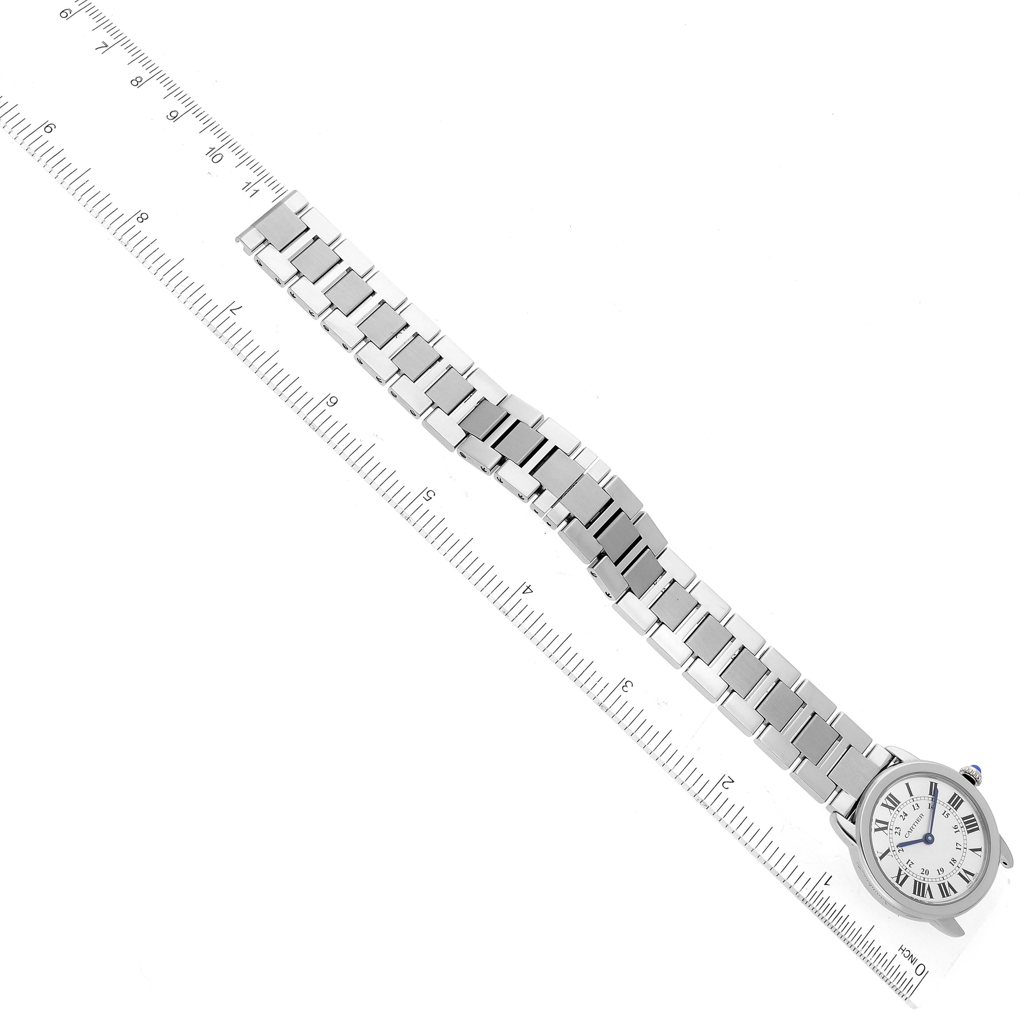 The image shows the Cartier Ronde W6701004 Women's Stainless Steel Silver Dial W6701004 Women's Stainless Steel Silver Dial watch laid flat with a ruler alongside its bracelet.