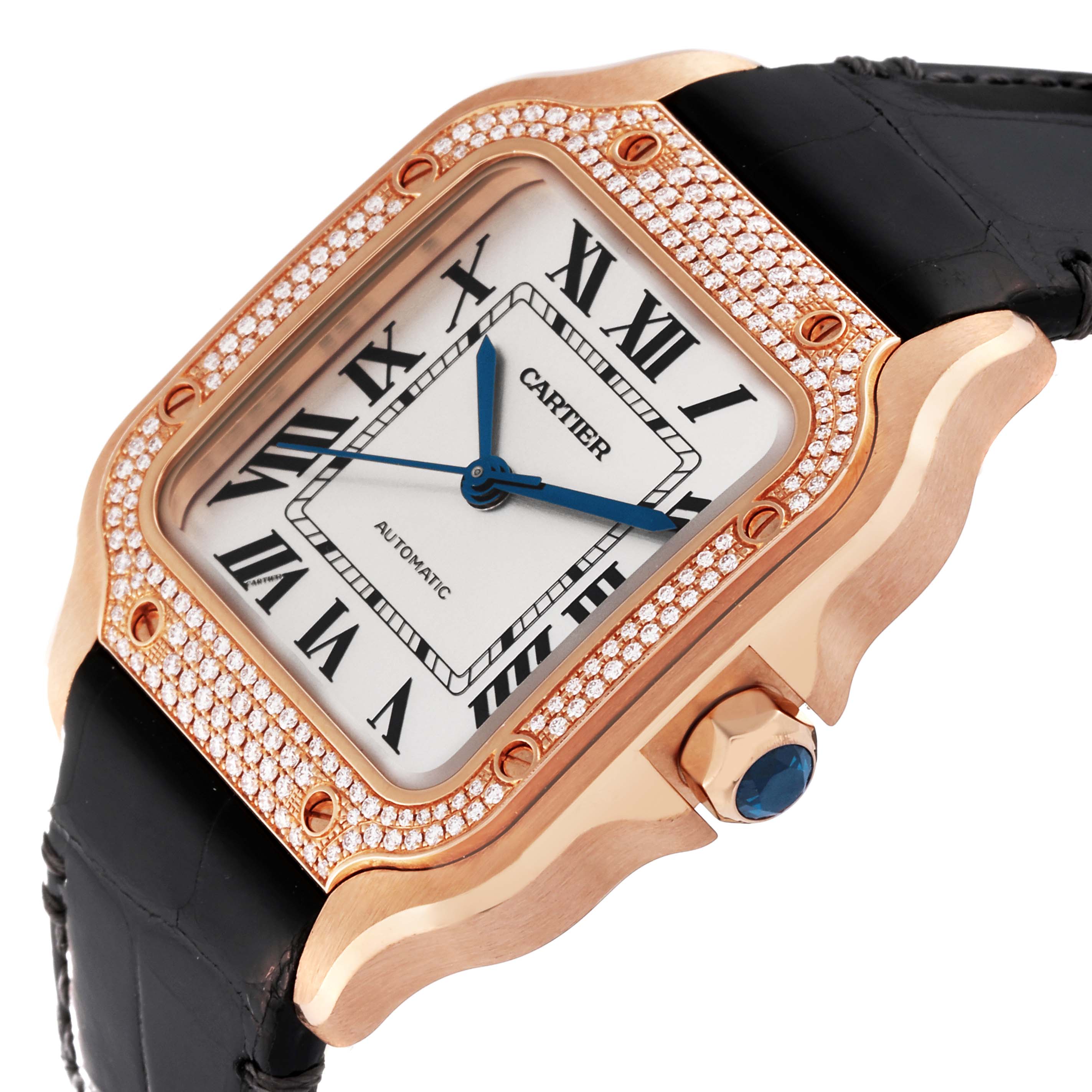 The Cartier Santos WJSA0007 Men's Rose Gold Silver Dial WJSA0007 Men's Rose Gold Silver Dial watch is shown at an angle highlighting its square face, diamond-studded bezel, blue hands, and part of its leather strap and crown.