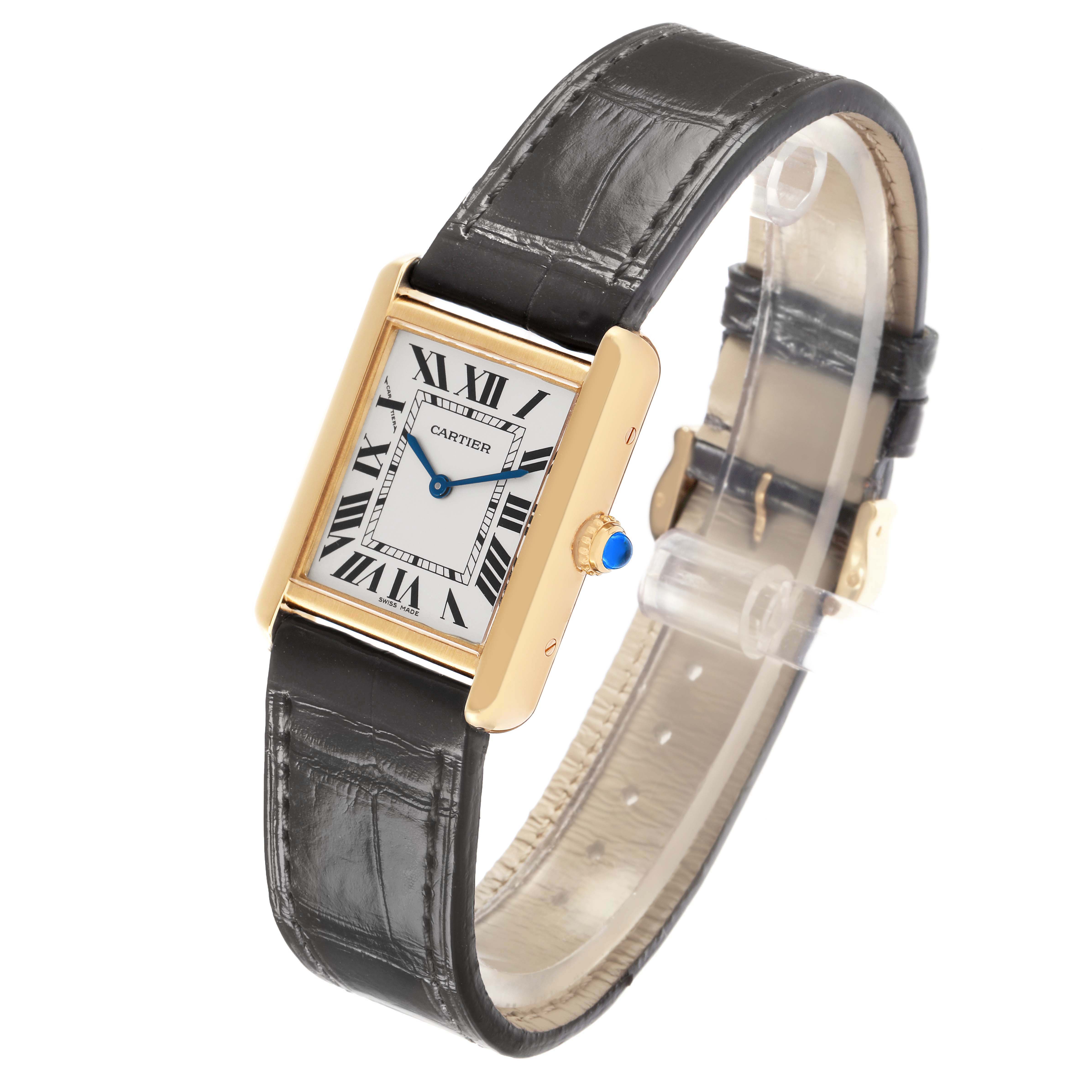 The Cartier Tank Solo, model W5200002, is shown at a three-quarter angle displaying the dial, crown with a blue stone, and the leather strap.