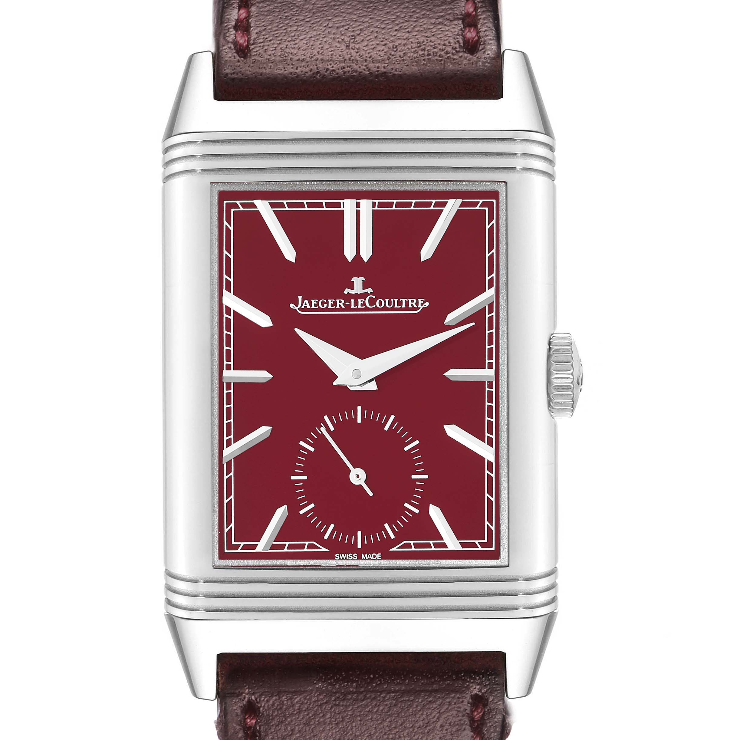 The Jaeger-LeCoultre Reverso watch is shown from the front, highlighting its red dial, silver hands, and rectangular case.