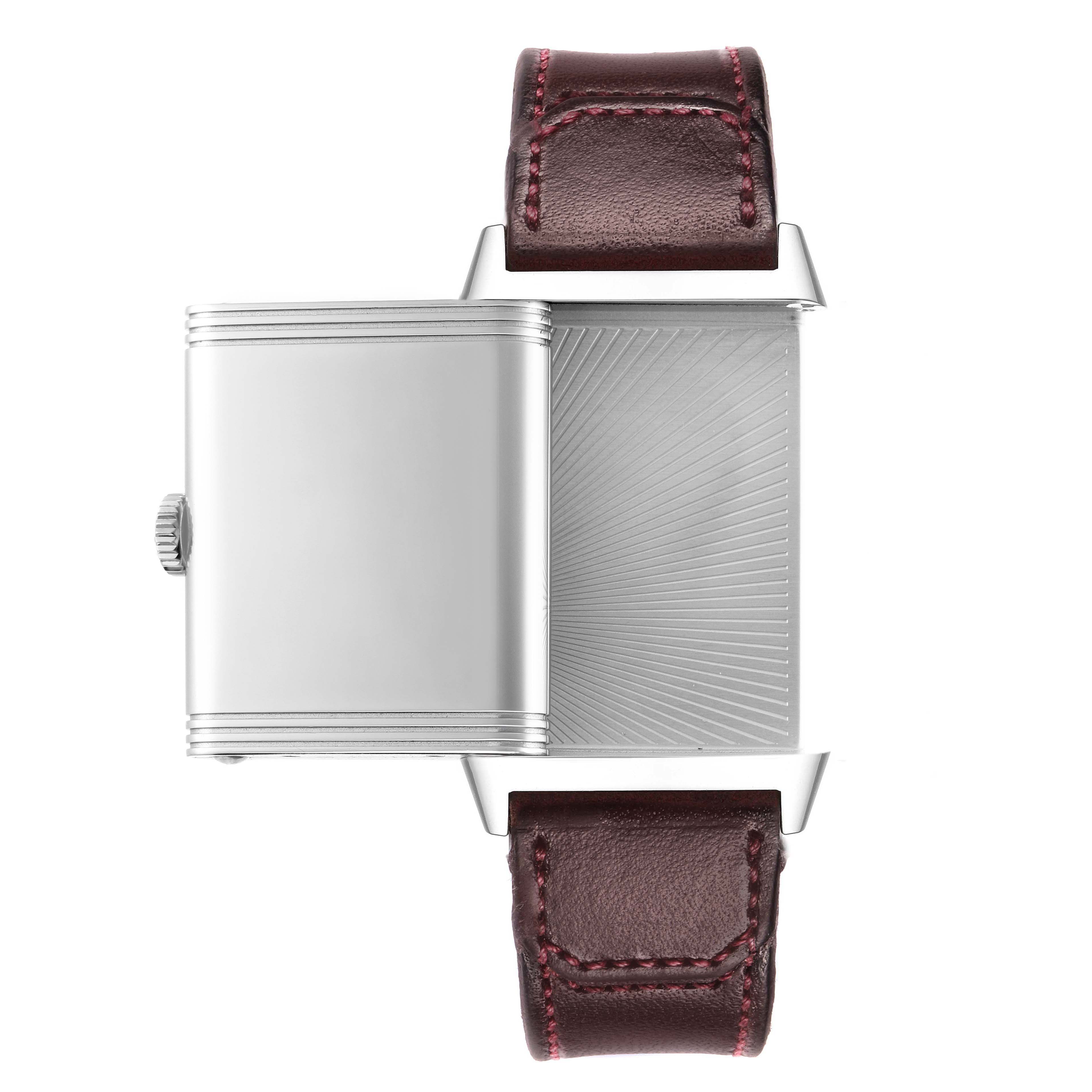 The Jaeger-LeCoultre Reverso watch is shown from the side angle, highlighting its swiveling case and textured back, with a brown leather strap.