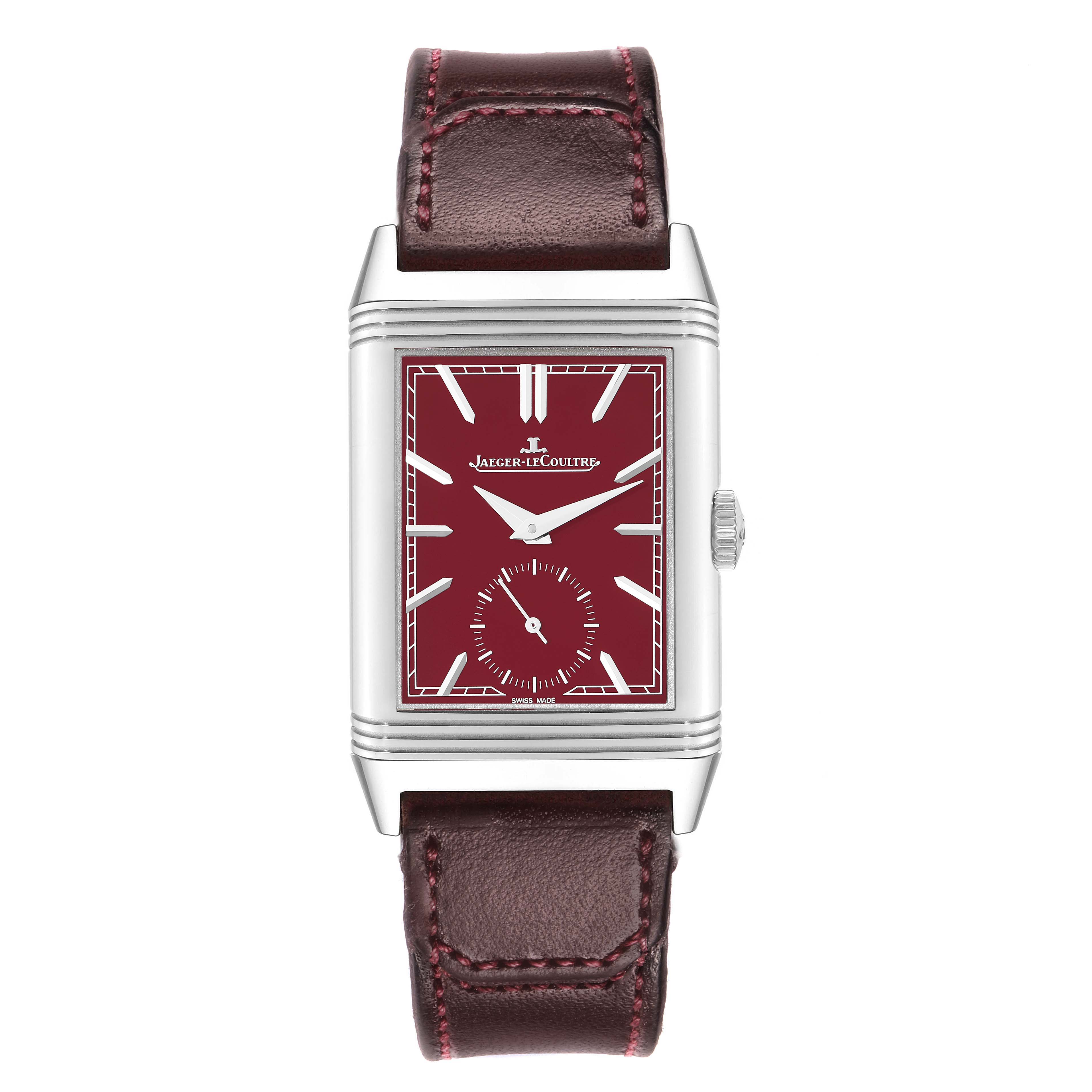 The Jaeger-LeCoultre Reverso watch is shown from the front, displaying its red dial, rectangular case, and leather strap.