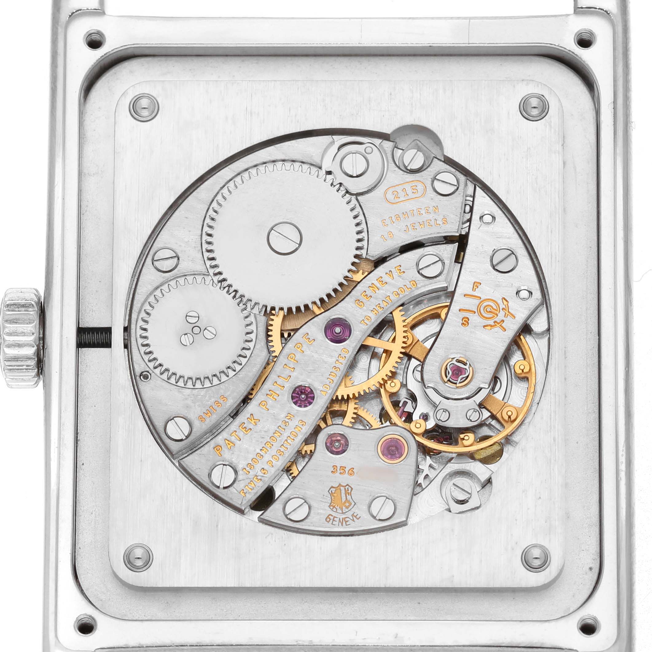 The image shows the movement of a Patek Philippe Gondolo 5112G Men's White Gold Black Dial watch from a rear angle, revealing gears and mechanical components.