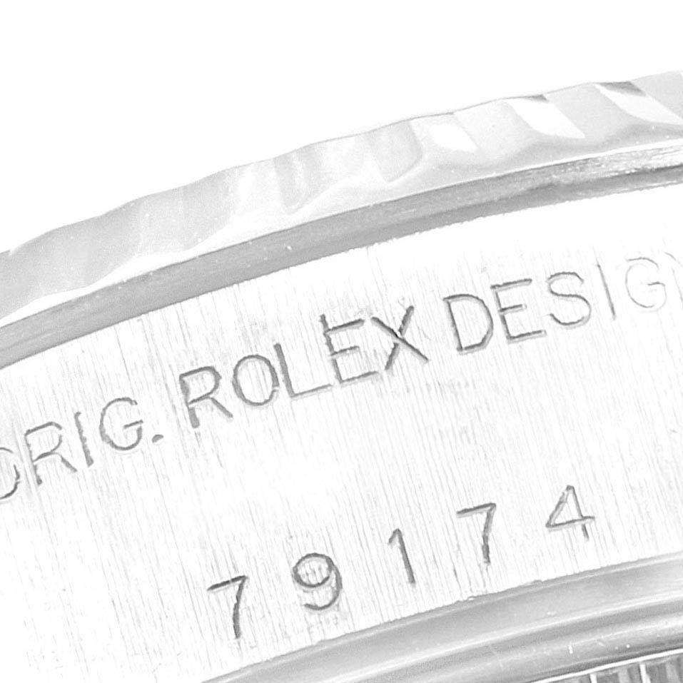 The image shows a close-up of the side of the Rolex Datejust 79174 Women
s Stainless Steel White Dial 79174 Women
s Stainless Steel White Dial watch case, highlighting the serial number and "ROLEX DESIGN" engraving.