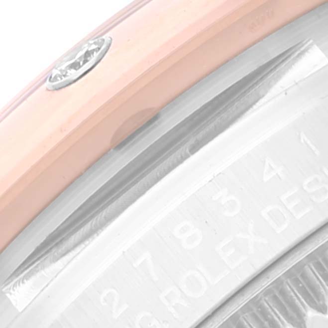 This close-up image of a Mid-Size Rolex watch shows a portion of the bezel, case side, and engraving.