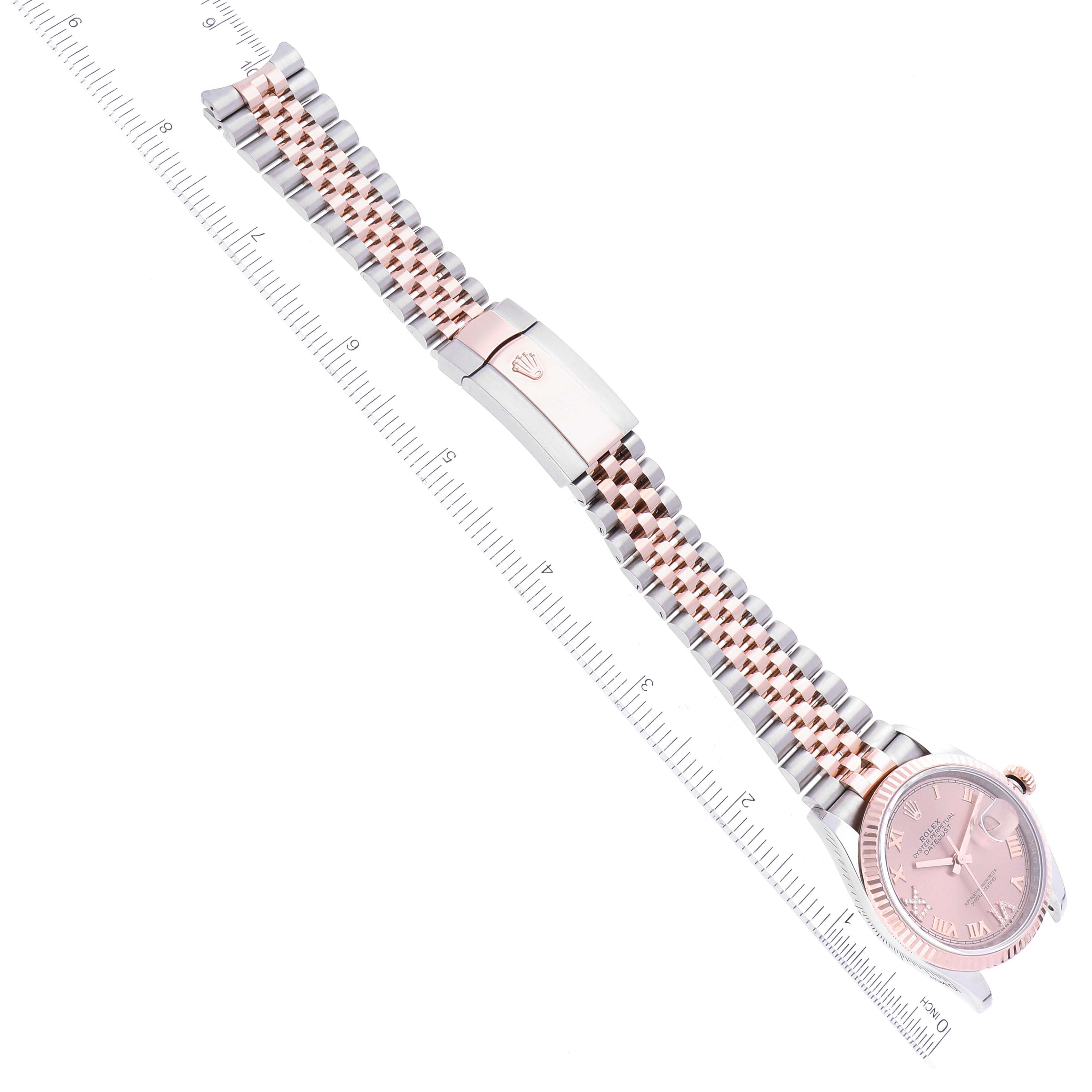 This image shows a Rolex Datejust 126231 Men's Steel and Gold (two tone) Pink Dial 126231 Men's Steel and Gold (two tone) Pink Dial watch at an angle displaying the face, bracelet, and clasp along with a ruler for scale.