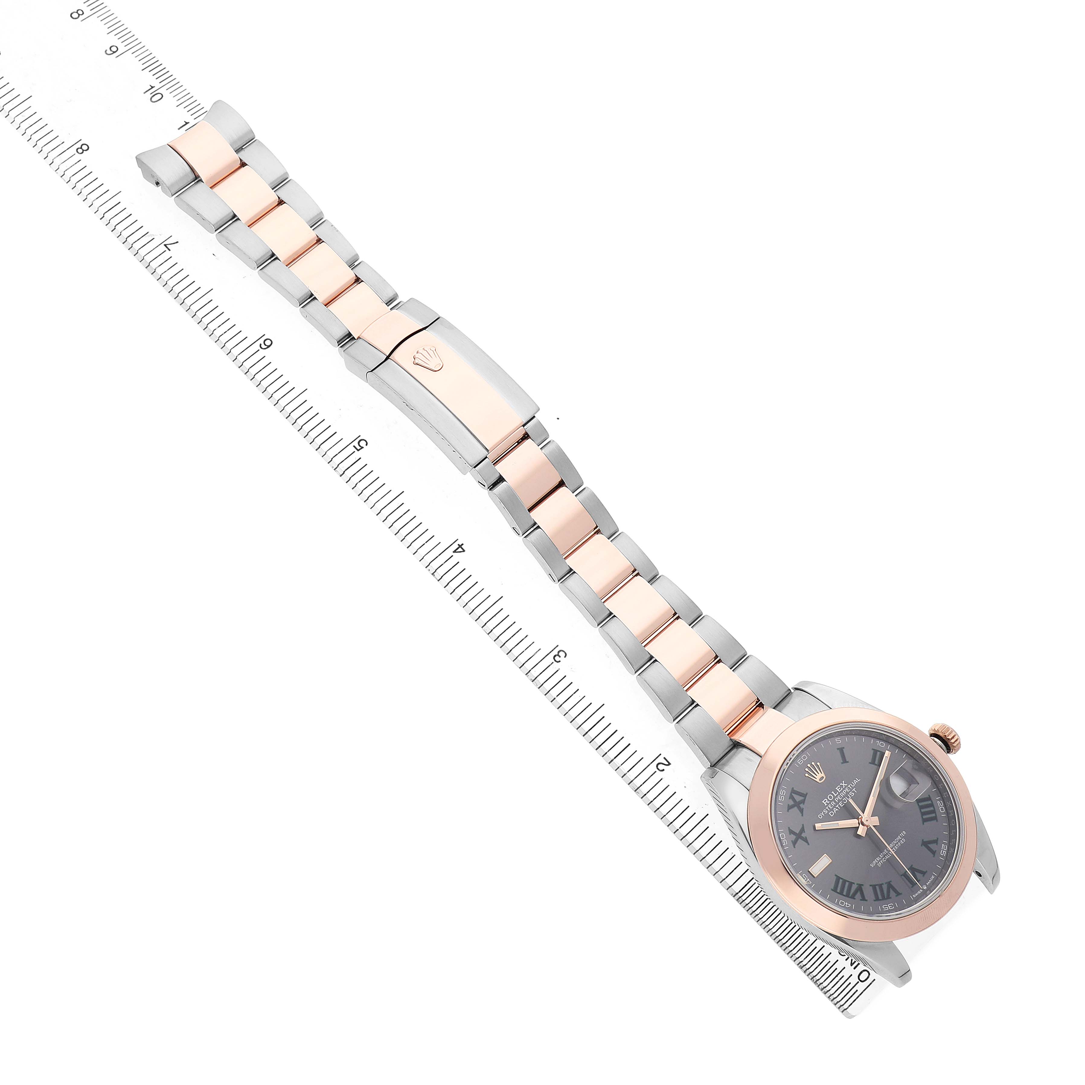 The Rolex Datejust 41 126301 Men's Steel and Gold (two tone) Grey Dial is shown at a top-down angle, highlighting the dial, bezel, bracelet, and clasp alongside a ruler for scale.
