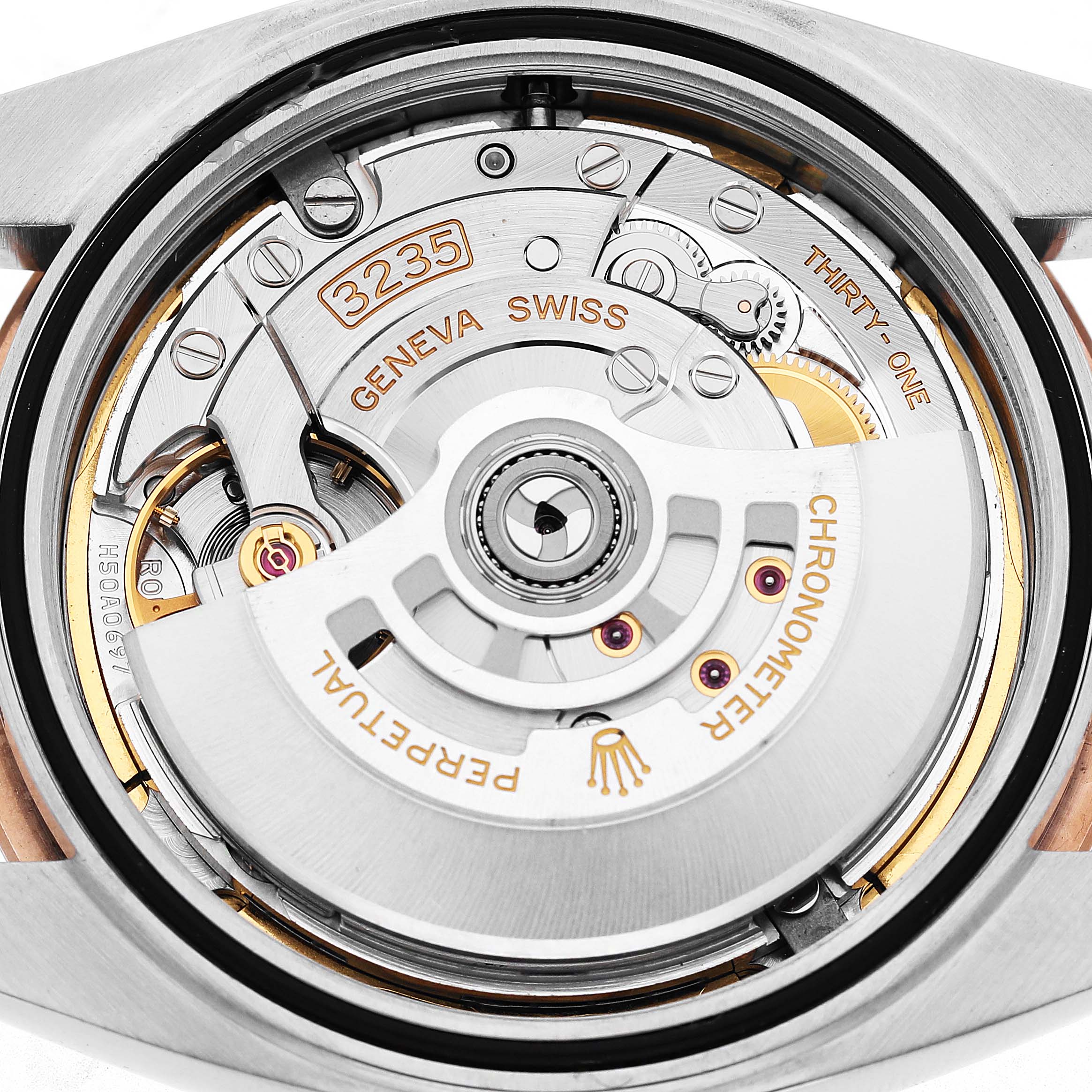 The image shows the movement of a Rolex Datejust 41 126301 Men's Steel and Gold (two tone) Grey Dial, featuring its intricate mechanical parts and inscriptions.
