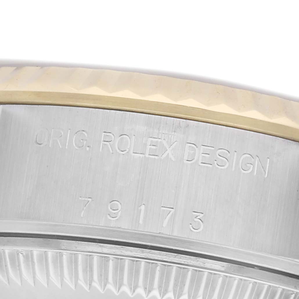The image shows the side of a Rolex Datejust 79173 Women's Steel and Gold (two tone) Champagne Dial 79173 Women's Steel and Gold (two tone) Champagne Dial watch case with an engraved model number and part of the bezel.