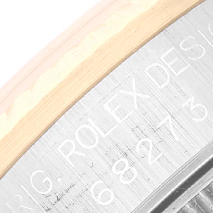 The image shows a close-up of the engraving on the side of the Mid-Size Rolex watch casing.