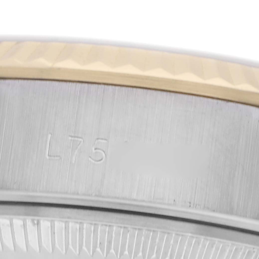 The image shows the side of a Rolex Datejust 69173 Women's Steel and Gold (two tone) White Dial 69173 Women's Steel and Gold (two tone) White Dial watch, focusing on part of the bezel with engraved marking.