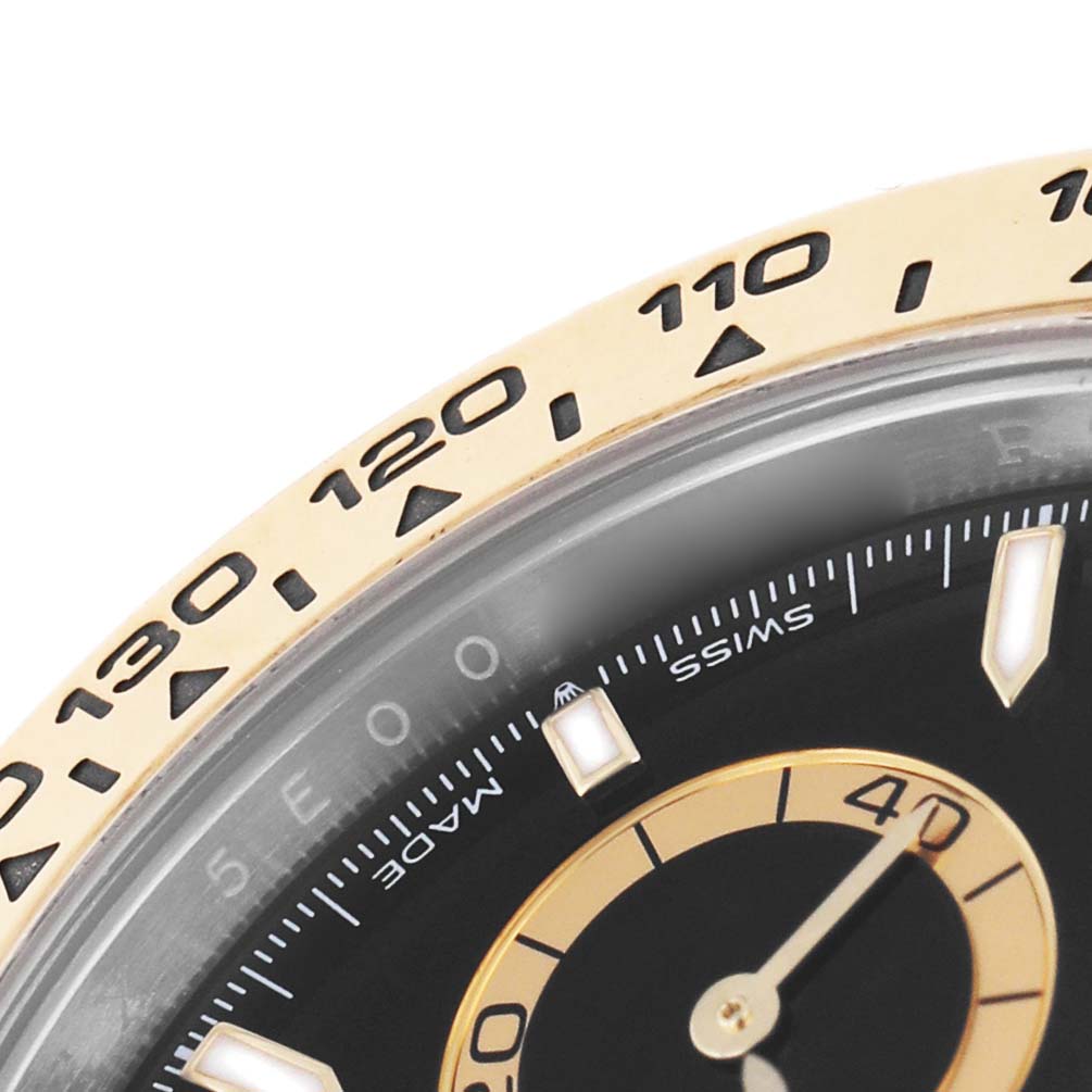 The image shows a close-up of the bezel and partial dial of a Rolex Daytona 126503 Men's Steel and Gold (two tone) Black Dial, highlighting the tachymetric scale and part of the subdial.