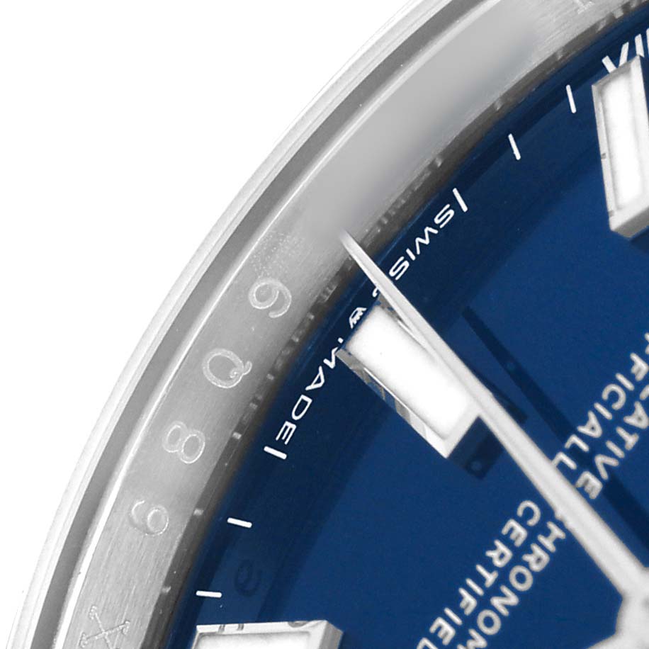 The image shows a close-up of the Oyster Perpetual Rolex watch, highlighting part of the blue dial and silver bezel.