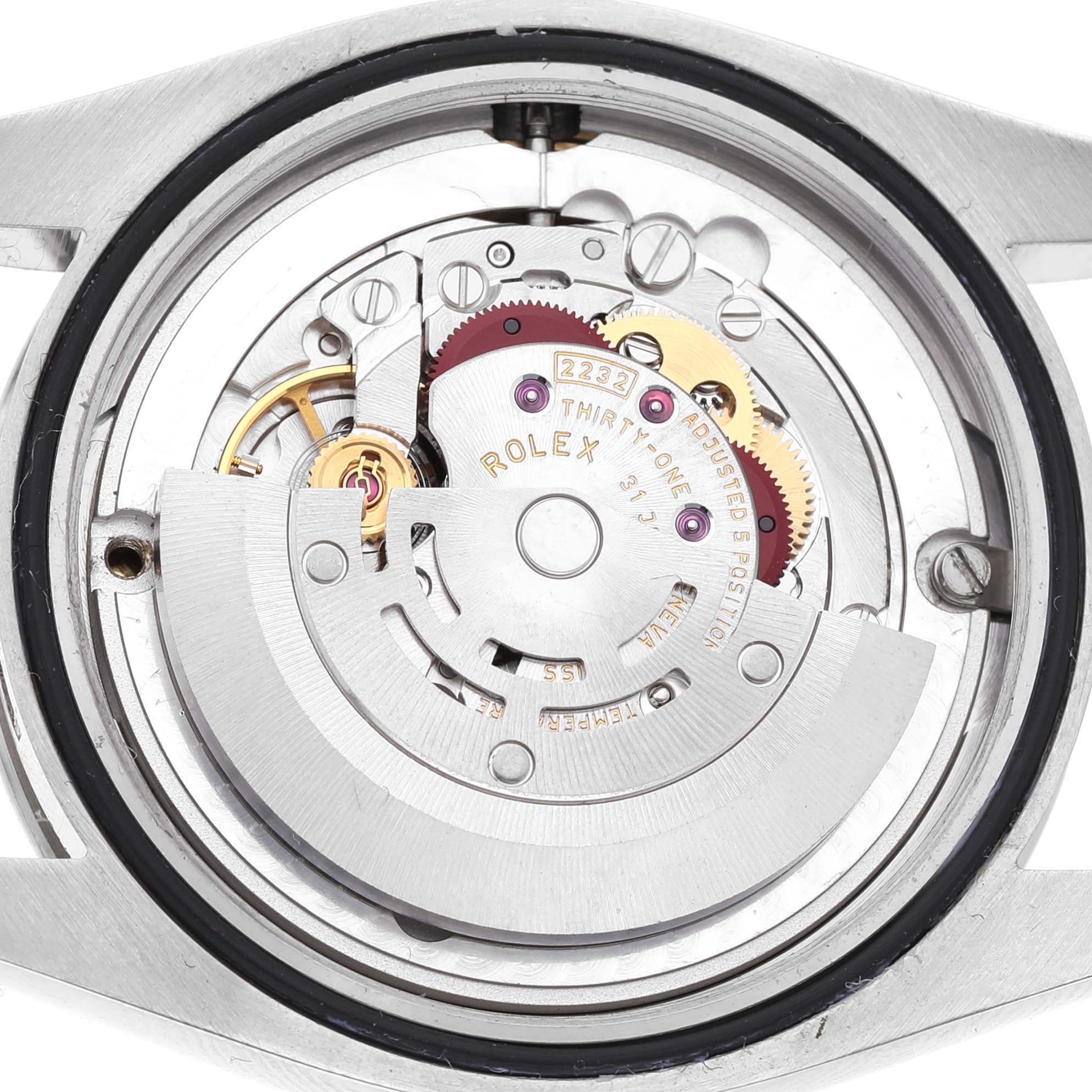 The image shows the movement of a Rolex Oyster Perpetual M124200-0003 Men's Stainless Steel Blue Dial watch from a top-down angle, revealing gears and mechanisms.