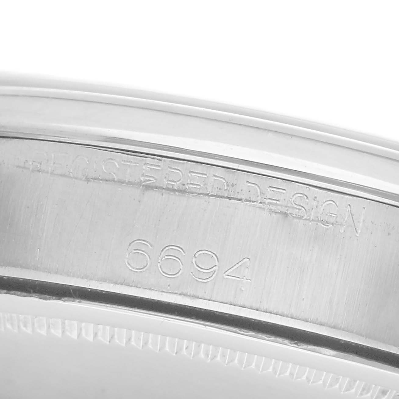 The image shows a close-up of the side of a Rolex Vintage Collection 6694 Men
s Stainless Steel Silver Dial 6694 Men
s Stainless Steel Silver Dial watch, focusing on the engraved model number and design.