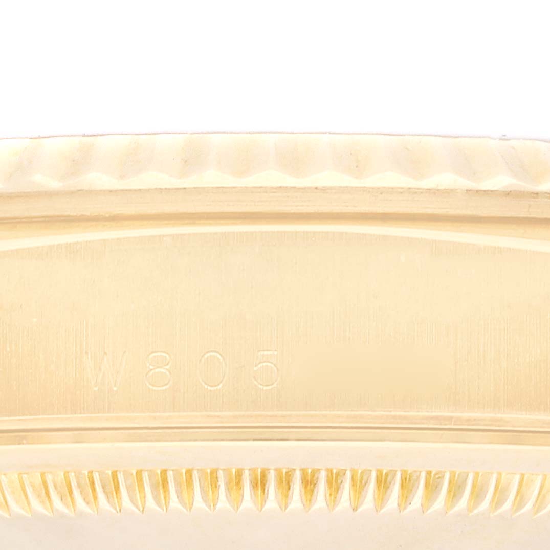This image shows a close-up of the bezel edge and part of the engraved serial number for a Rolex President 18238 Men's Yellow Gold Black Dial 18238 Men's Yellow Gold Black Dial model watch.