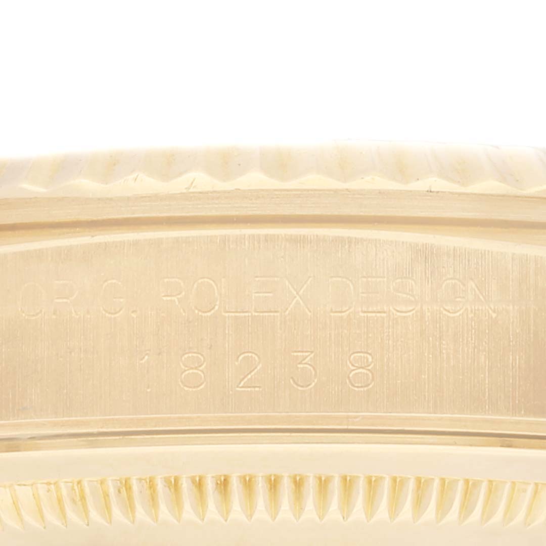 This image shows a close-up of the side of a Rolex President 18238 Men's Yellow Gold Black Dial 18238 Men's Yellow Gold Black Dial model with the engravings "ORIG. ROLEX DESIGN 18238."