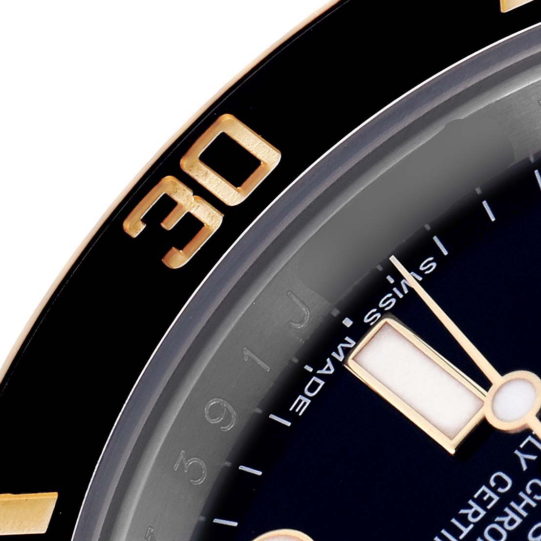 The image shows a close-up of the Rolex Submariner 116613 Men's Steel and Gold (two tone) Black Dial 116613 Men's Steel and Gold (two tone) Black Dial's dial and bezel, highlighting the 30-minute mark and part of the watch face.