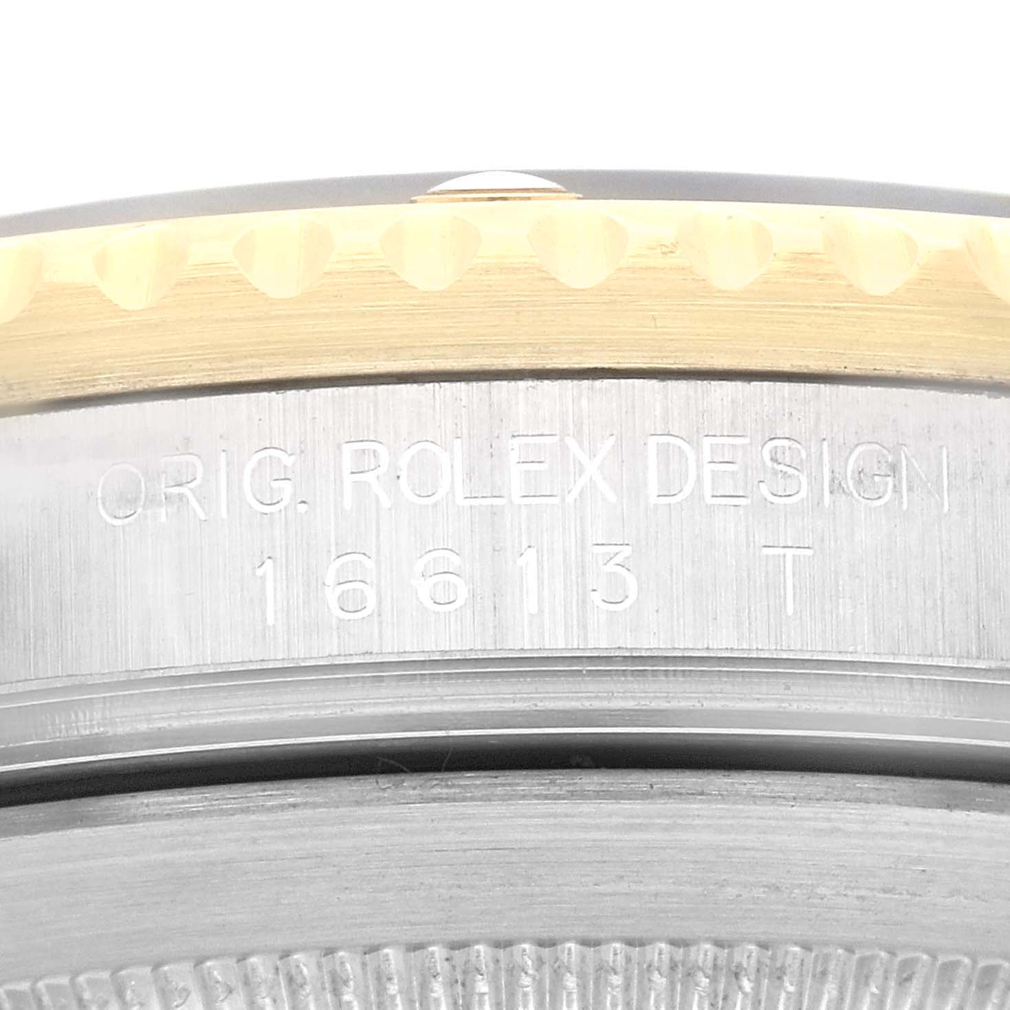 The image shows a close-up of the side of a Rolex Submariner 16613 Men's Steel and Gold (two tone) Black Dial 16613 Men's Steel and Gold (two tone) Black Dial's case with model number 16613 T engraved.