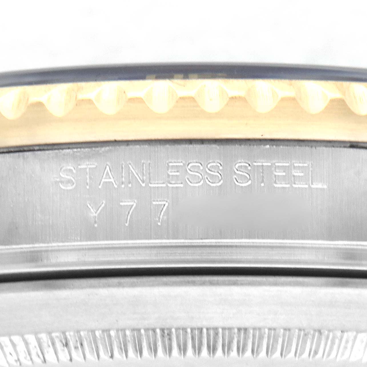 The image shows the side engraving and edge of the bezel of a Rolex Submariner 16613 Men's Steel and Gold (two tone) Blue Dial 16613 Men's Steel and Gold (two tone) Blue Dial watch, highlighting "STAINLESS STEEL" and a partial serial number.