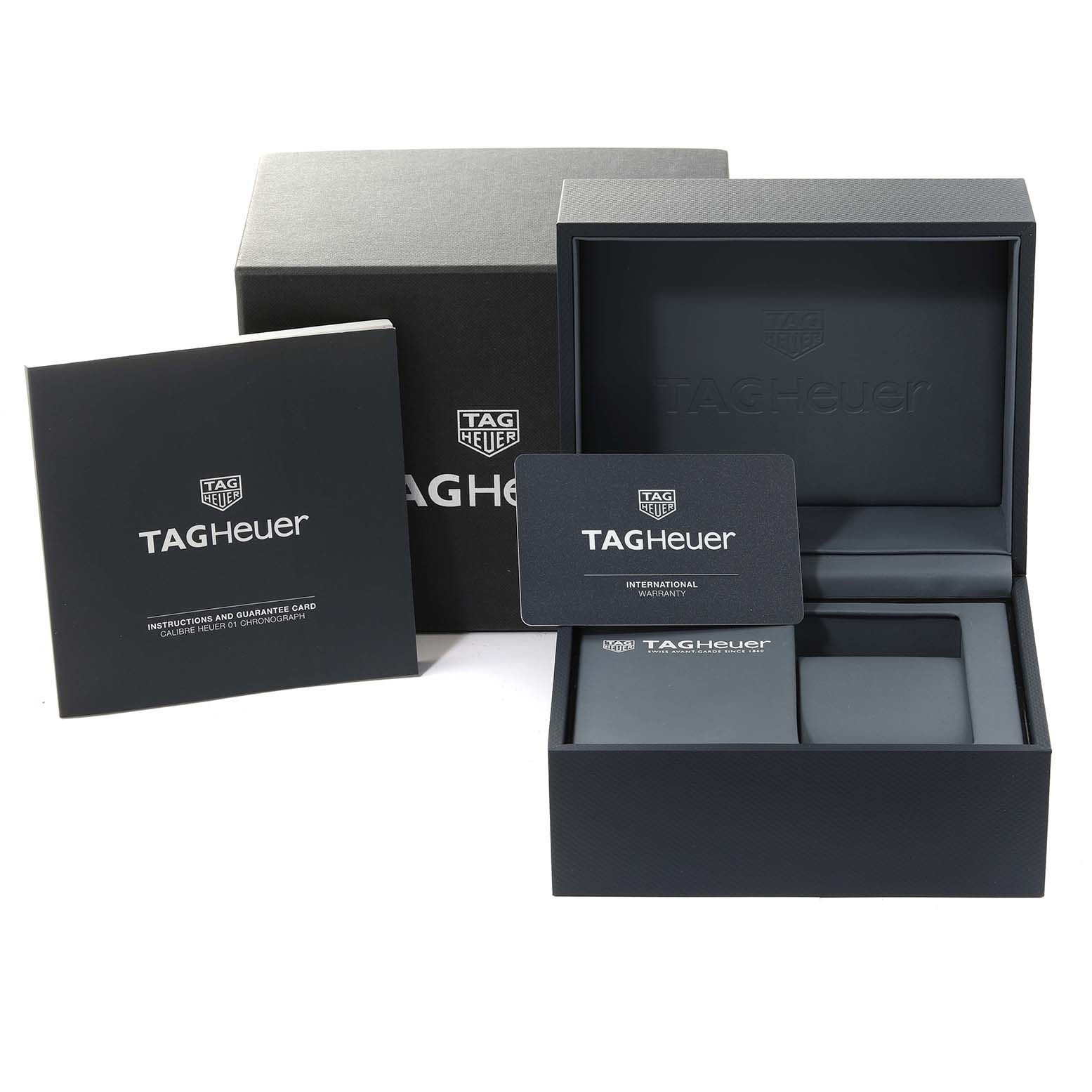 The image shows the packaging and accessories of a Carrera model Tag Heuer watch, including the box, instruction manual, and warranty card.