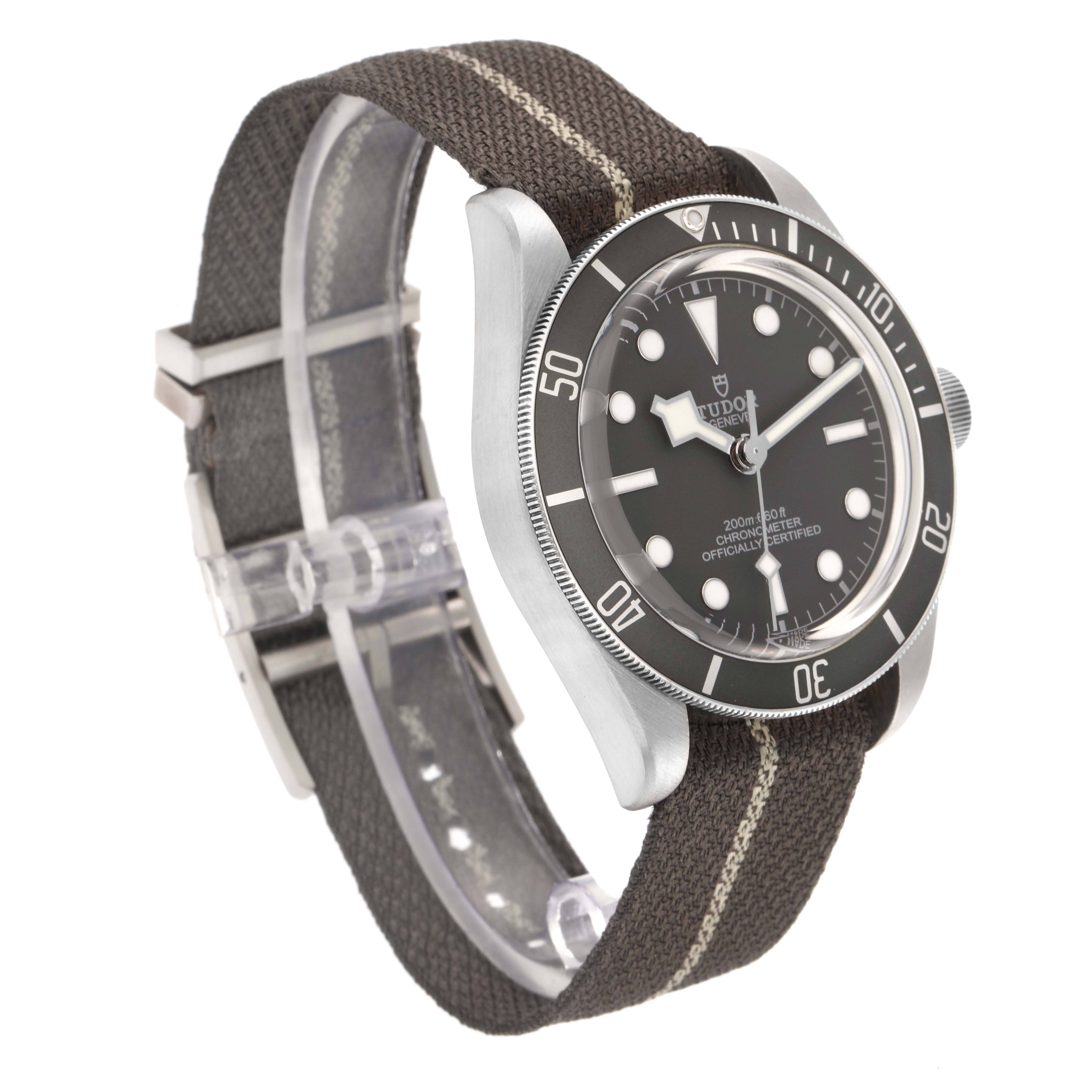 The Tudor Heritage Black Bay 79010 Men
s Stainless Steel Grey Dial 79010 Men
s Stainless Steel Grey Dial watch is shown at an angled side view, highlighting the bezel, dial, and fabric strap.