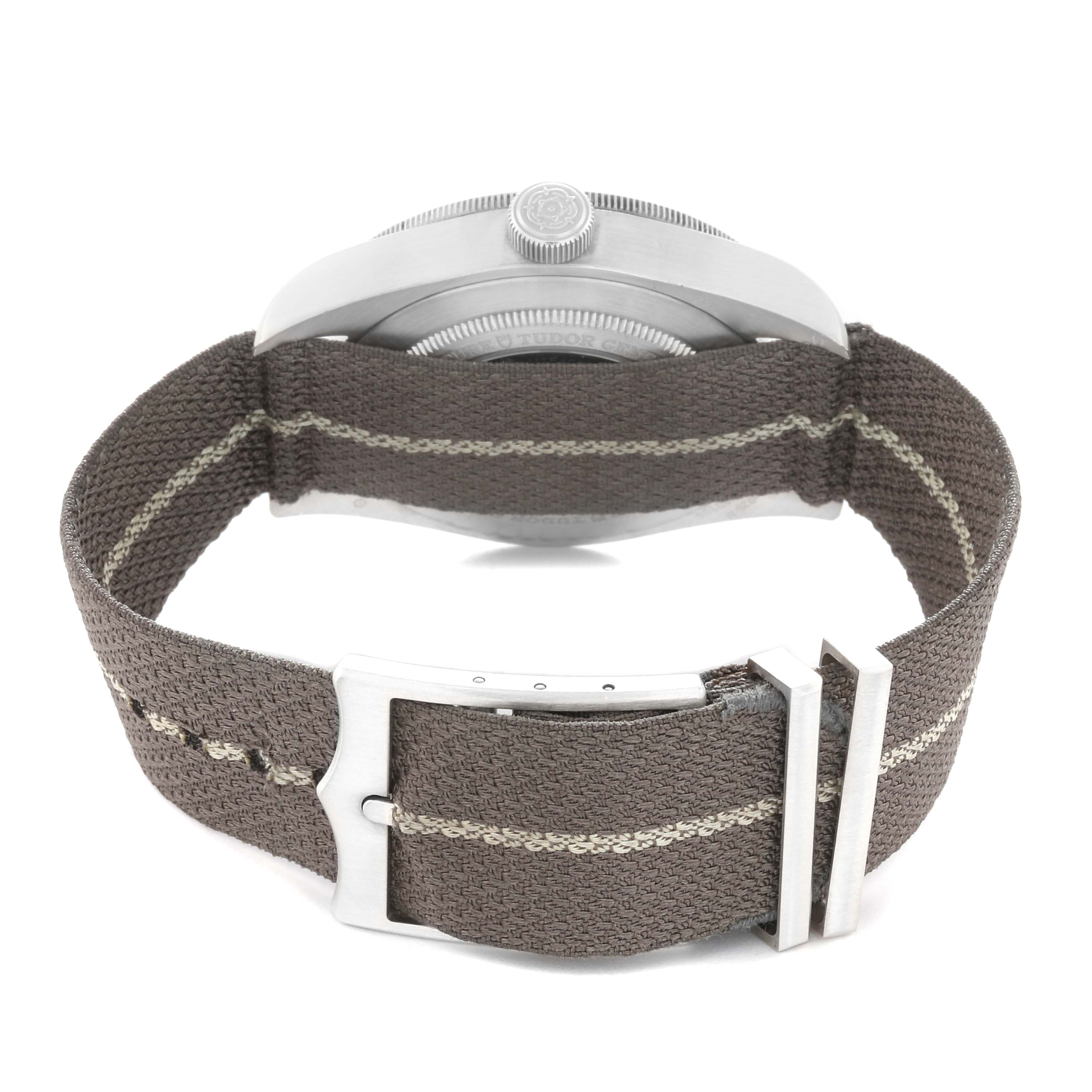 The image shows the Tudor Heritage Black Bay 79010 Men
s Stainless Steel Grey Dial 79010 Men
s Stainless Steel Grey Dial watch from the rear, highlighting the side profile and fabric strap with buckle.