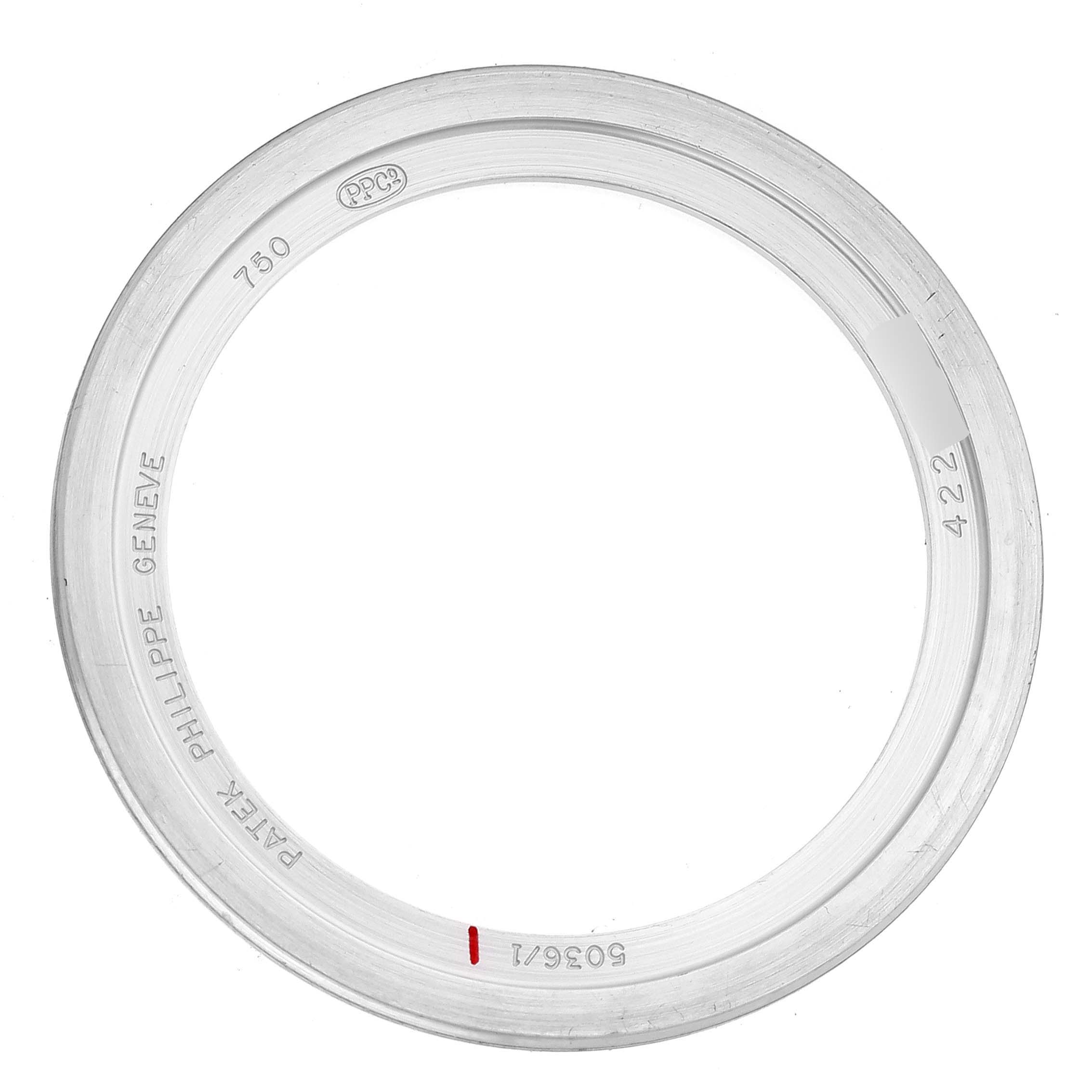 This image shows a bezel of a Patek Philippe Complications 5036/1G Men's White Gold Black Dial 5036/1G Men's White Gold Black Dial watch from a top-down angle, displaying various serial markings.