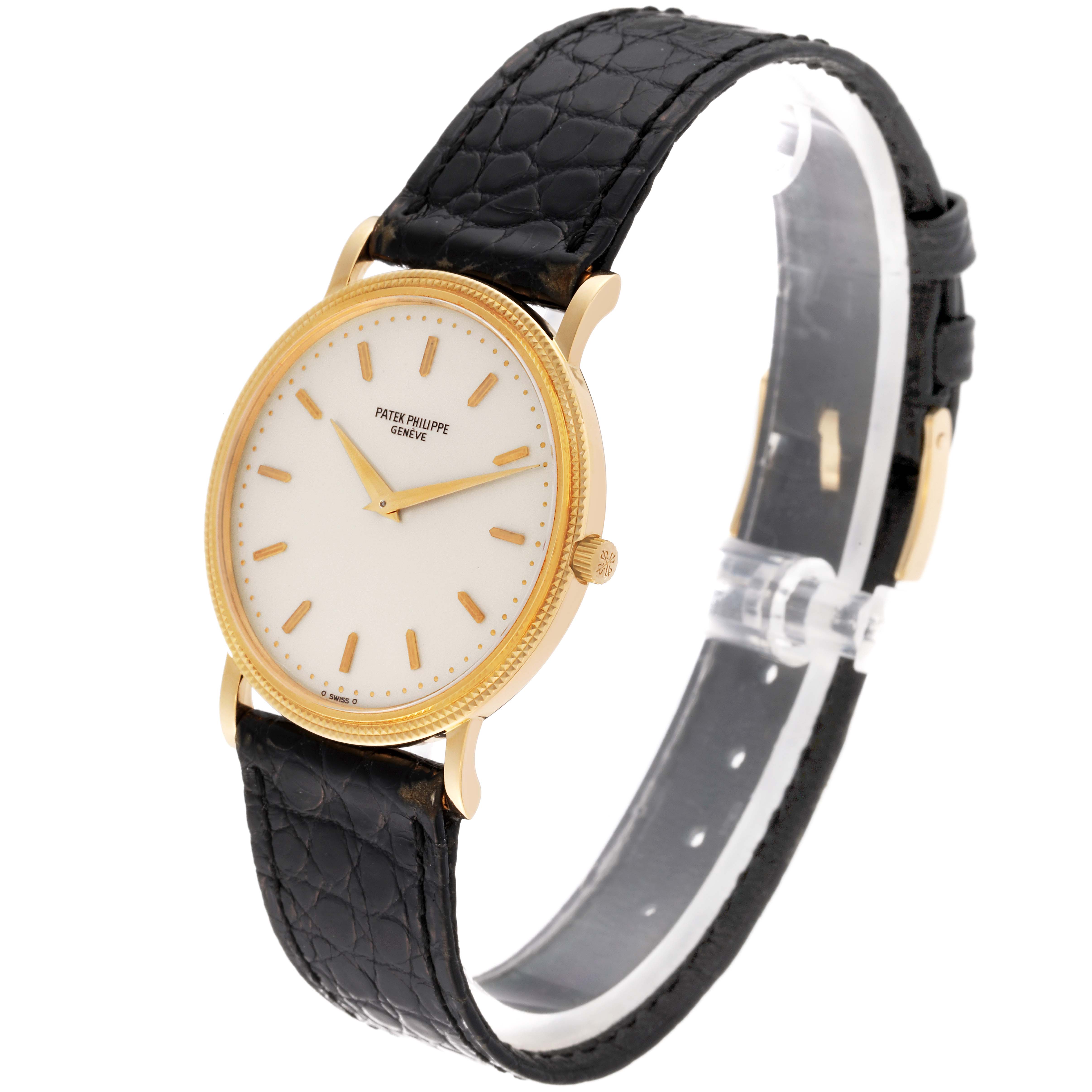 The image shows a side-angle view of a Patek Philippe Calatrava 3520D Men's Yellow Gold Beige Dial 3520D Men's Yellow Gold Beige Dial watch, highlighting its gold case and black leather strap.