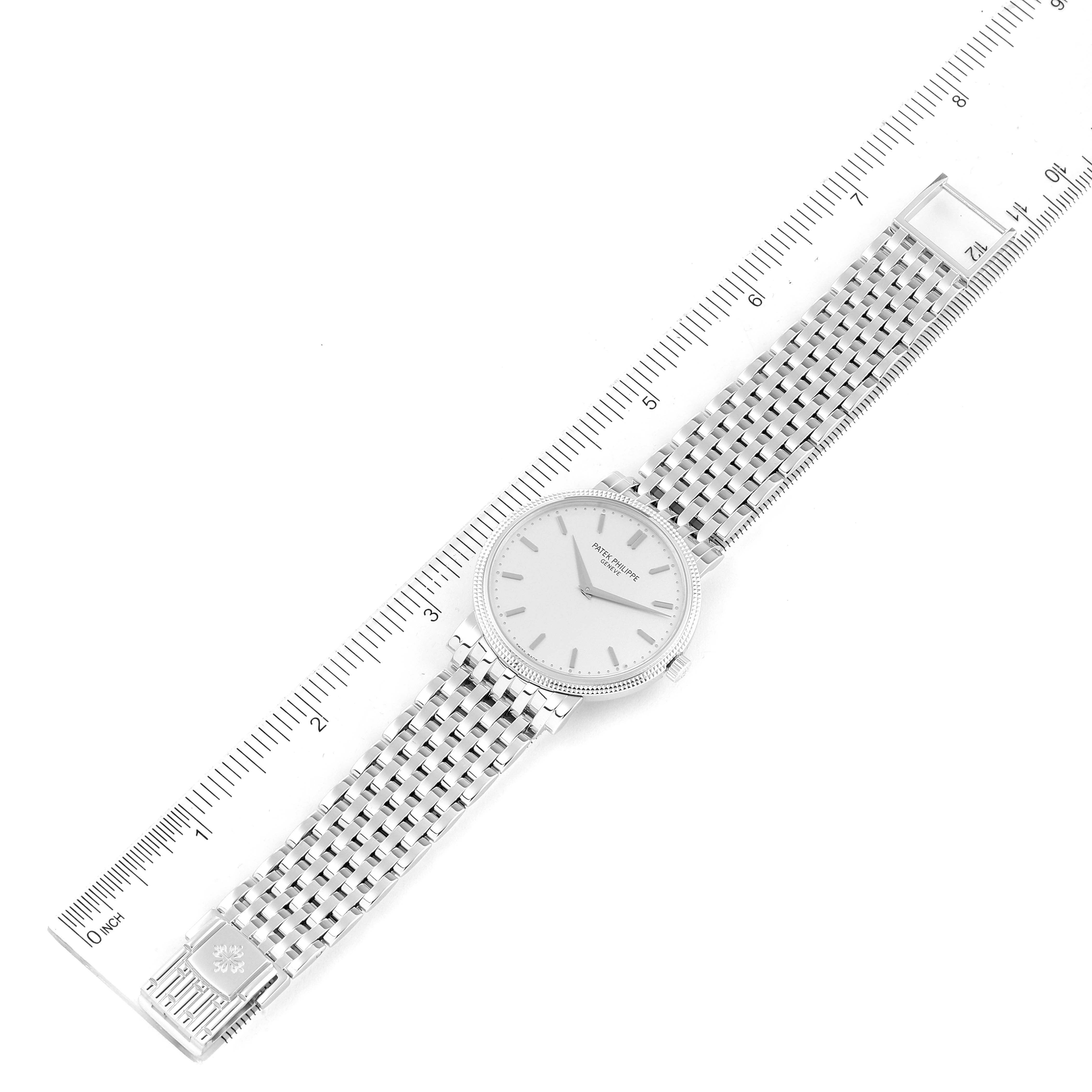 The image shows an overhead view of the Patek Philippe Calatrava 5120/1G-001 Men's White Gold Silver Dial 5120/1G-001 Men's White Gold Silver Dial watch next to a ruler.