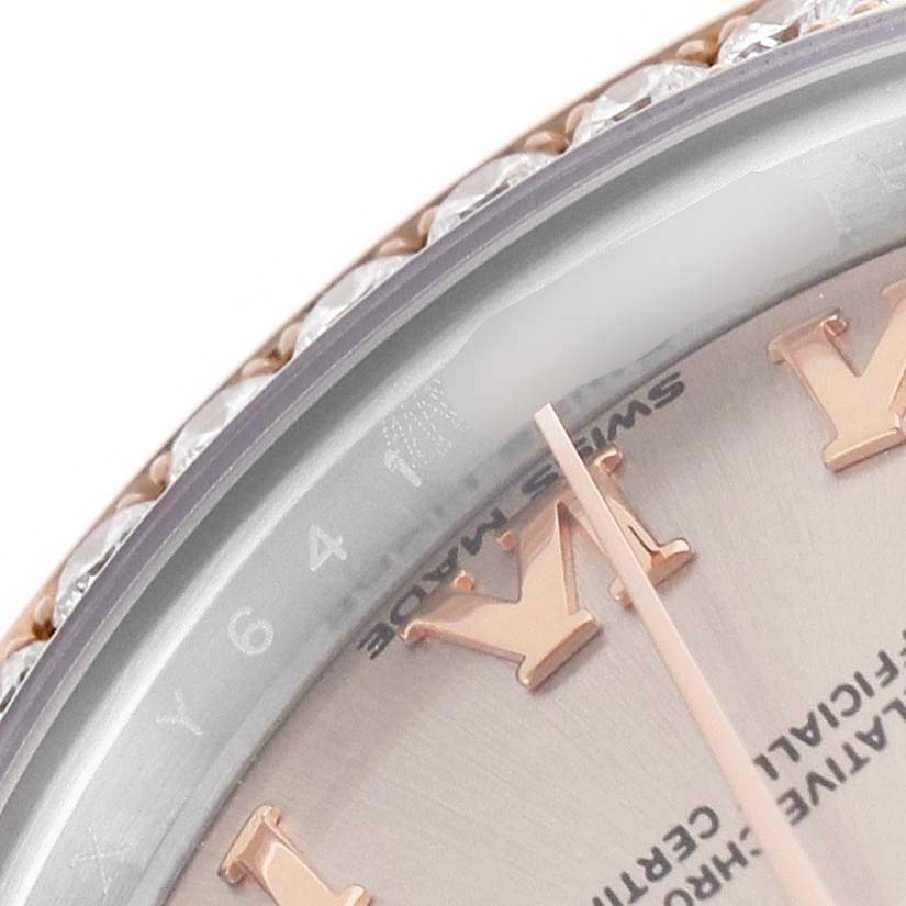 The image shows a close-up of the dial and bezel of a Rolex Datejust 279381RBR Women's Steel and Gold (two tone) Pink Dial, highlighting the Roman numerals and a diamond-encrusted bezel.