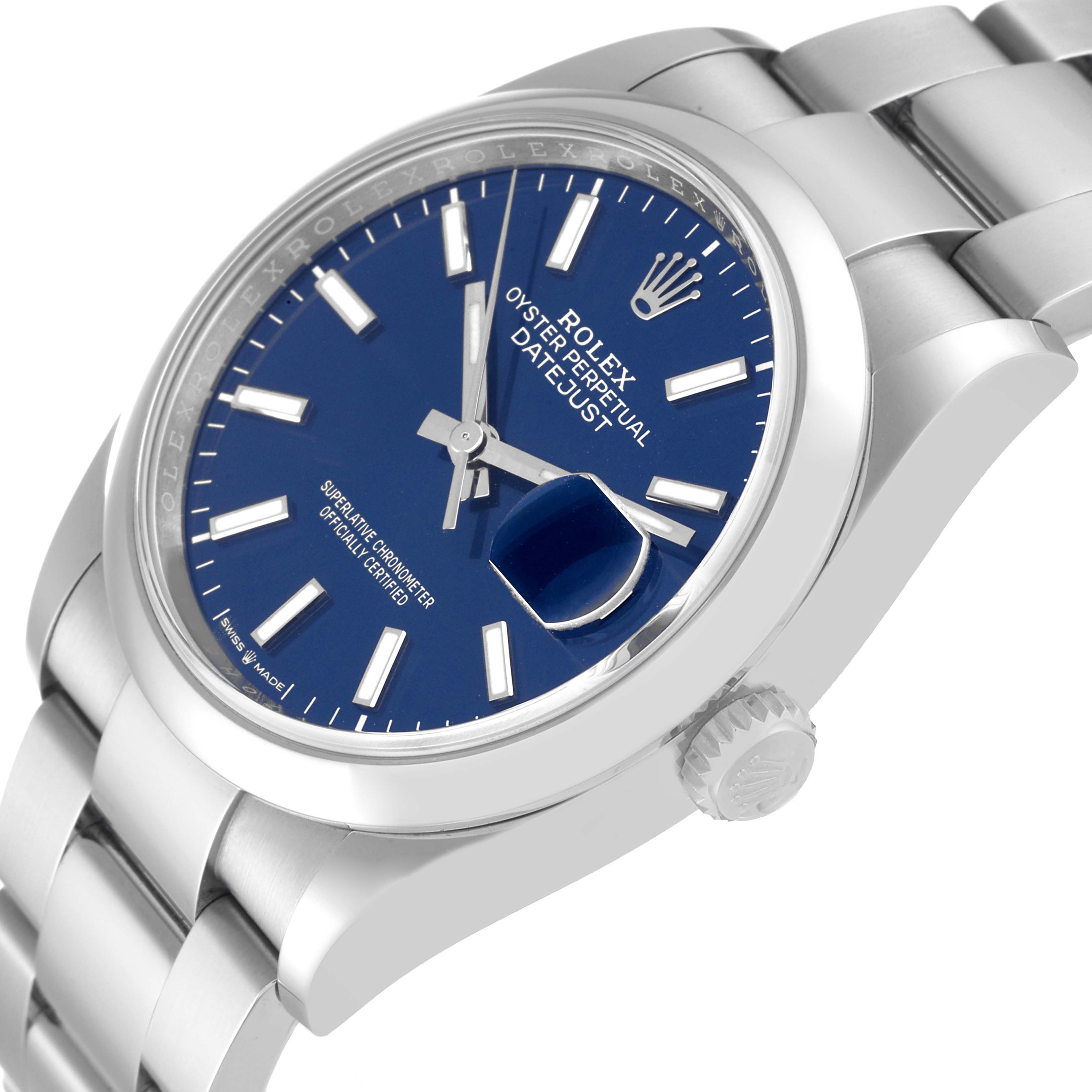 The image shows a close-up, angled view of a Rolex Datejust 126200 Men's Stainless Steel Blue Dial 126200 Men's Stainless Steel Blue Dial watch, highlighting the blue dial, crown, and part of the bracelet.