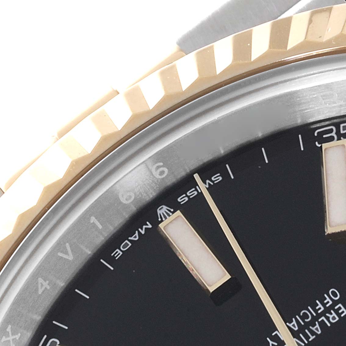 This image shows a close-up of the dial and the fluted bezel of the Rolex Datejust 41 126333 Men's Steel and Gold (two tone) Black Dial 126333 Men's Steel and Gold (two tone) Black Dial, highlighting the hour markers and the "Swiss Made" text.