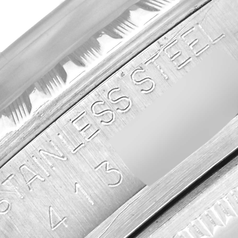 This close-up image shows the "STAINLESS STEEL" engraving on the side of a Rolex Vintage Collection 1603 Men's Stainless Steel Blue Dial 1603 Men's Stainless Steel Blue Dial watch case.