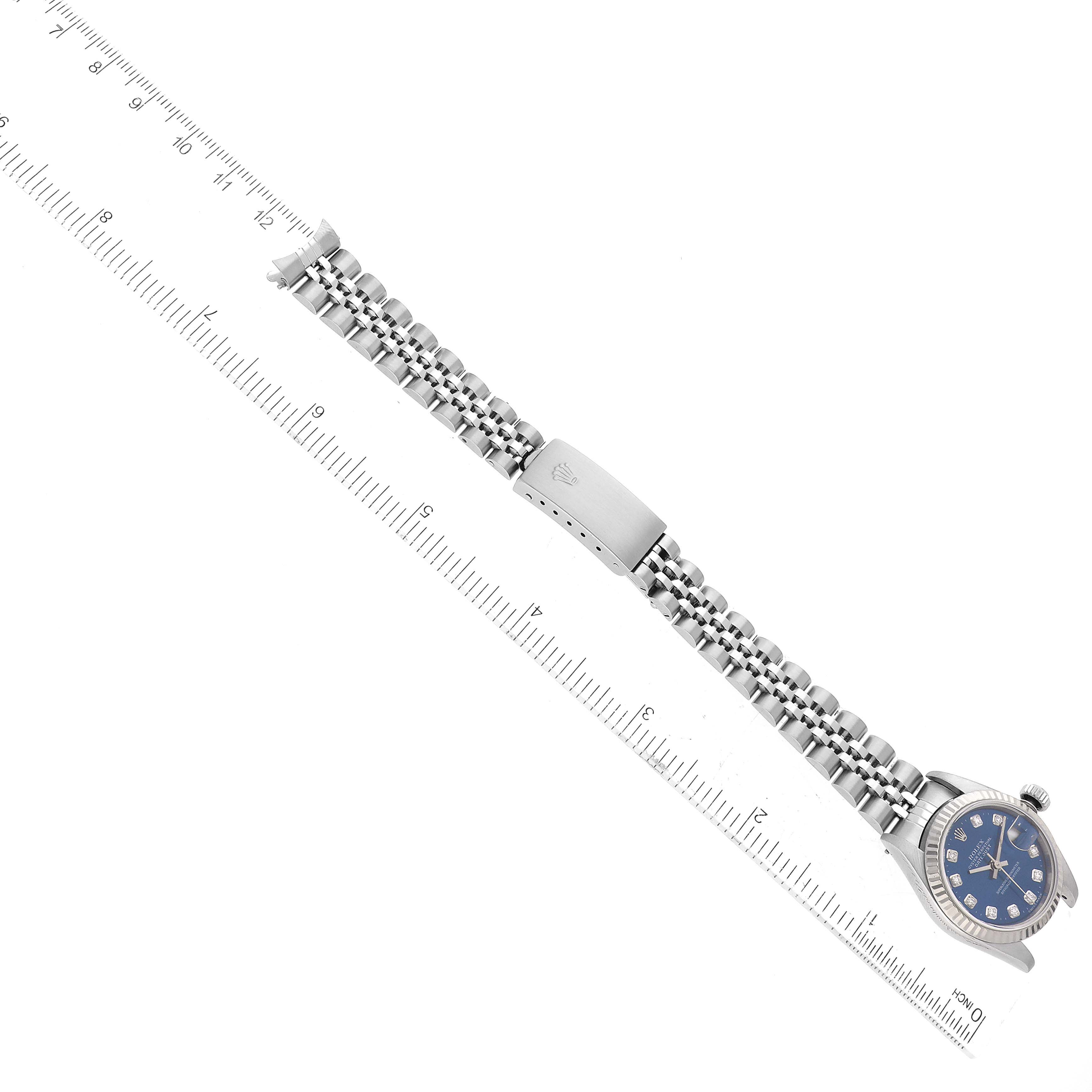 The image shows a Rolex Datejust 79174 Women's Stainless Steel Blue Dial 79174 Women's Stainless Steel Blue Dial watch laid next to a ruler, highlighting its bracelet and clasp.