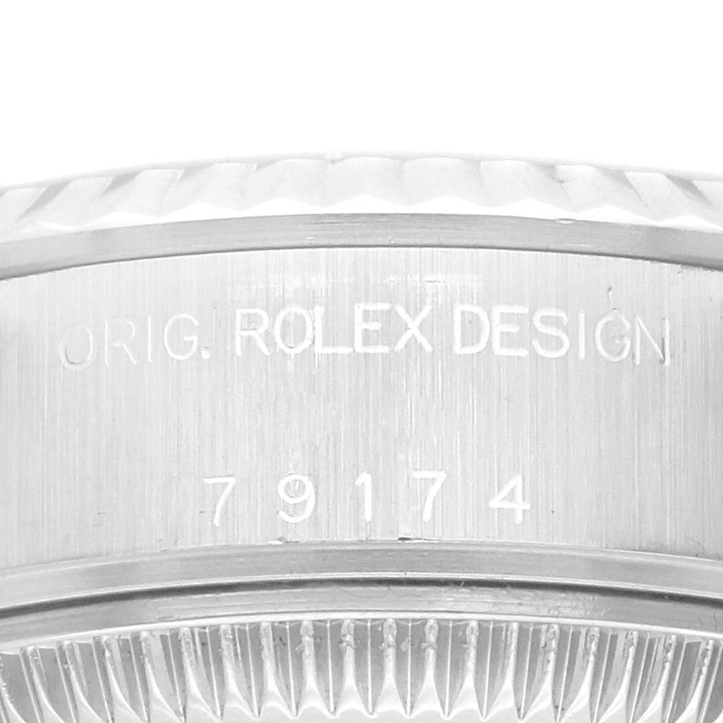 This close-up image shows part of the bezel of a Rolex Datejust 79174 Women's Stainless Steel Blue Dial 79174 Women's Stainless Steel Blue Dial watch with engraved text displaying the design and model number.