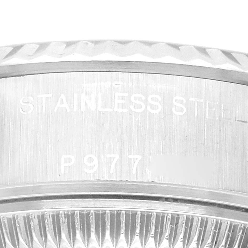 The image shows a close-up of the side view of a Rolex Datejust 79174 Women's Stainless Steel Blue Dial 79174 Women's Stainless Steel Blue Dial watch bezel and part of the case back, displaying markings.