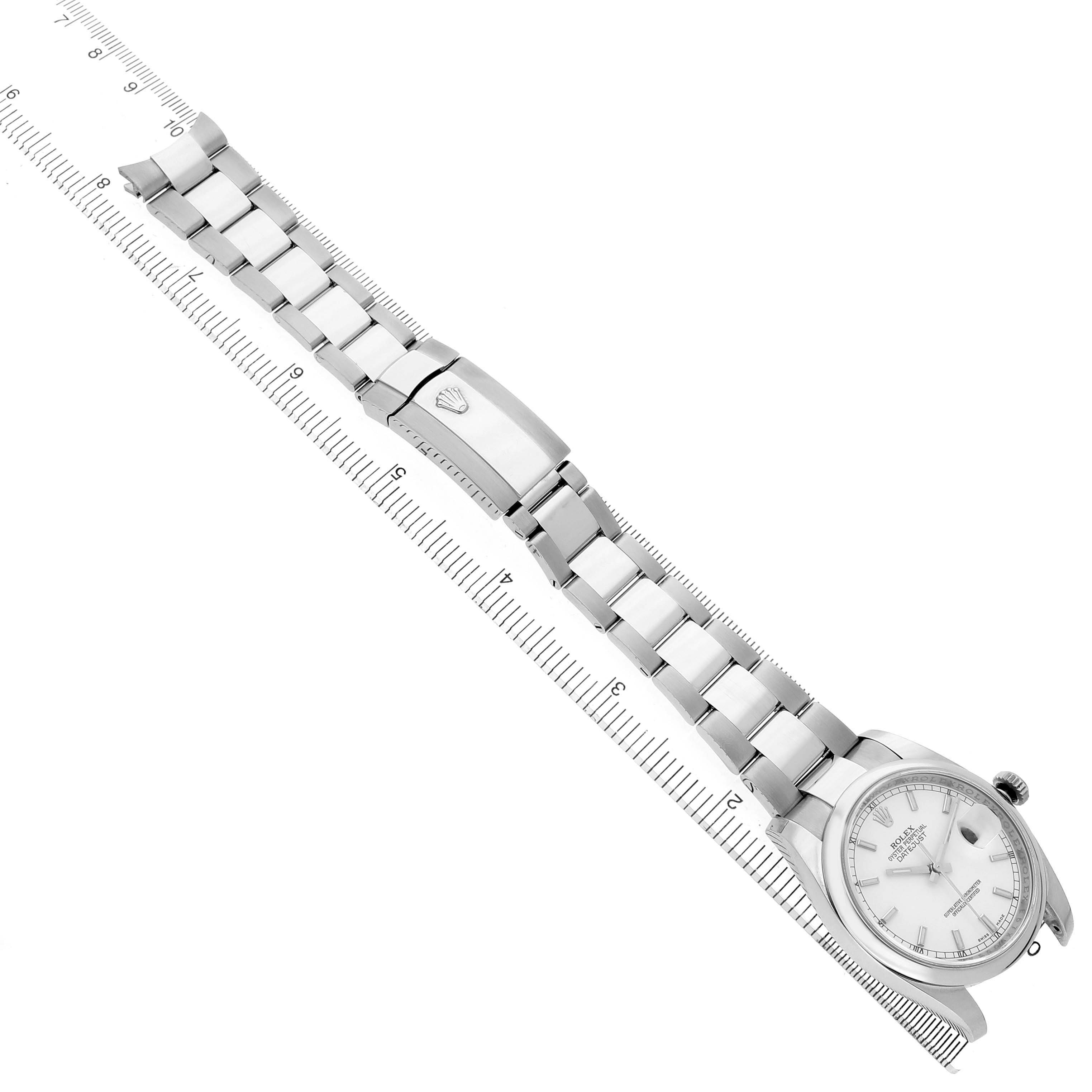 The Rolex Datejust 116200 Men's Stainless Steel White Dial watch is shown diagonally from an overhead angle, highlighting the face, bracelet, and clasp with a ruler for scale.