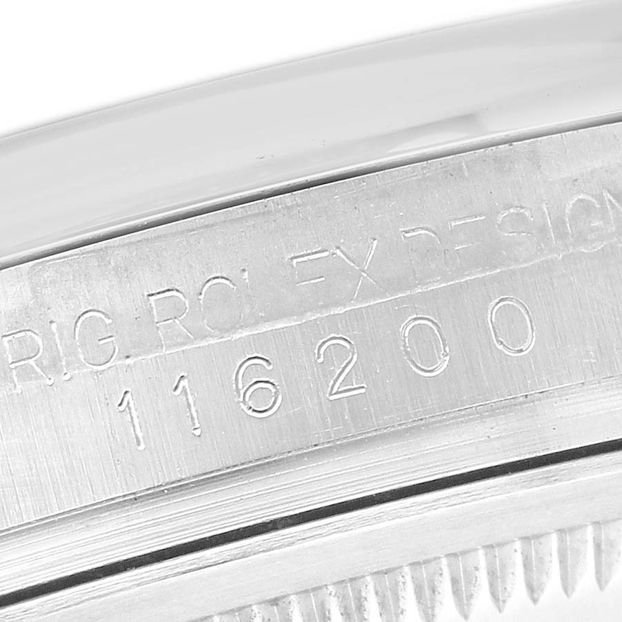 The image shows the side angle of the case between the lugs of a Rolex Datejust 116200 Men's Stainless Steel White Dial, highlighting the engraved model number.