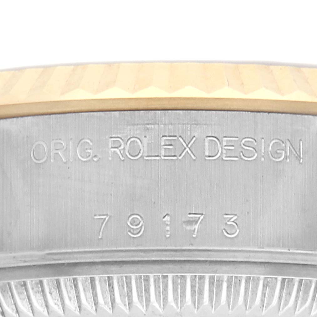 The image shows a close-up of the side of a Rolex Datejust 79173 Women's Steel and Gold (two tone) Silver Dial 79173 Women's Steel and Gold (two tone) Silver Dial case, featuring the model number and the phrase "ORIG. ROLEX DESIGN".