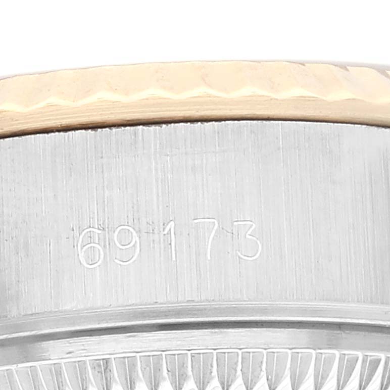 The image shows a close-up angle of the serial number and part of the case and bezel of a Rolex Datejust 69173 Women's Steel and Gold (two tone) Champagne Dial 69173 Women's Steel and Gold (two tone) Champagne Dial watch.