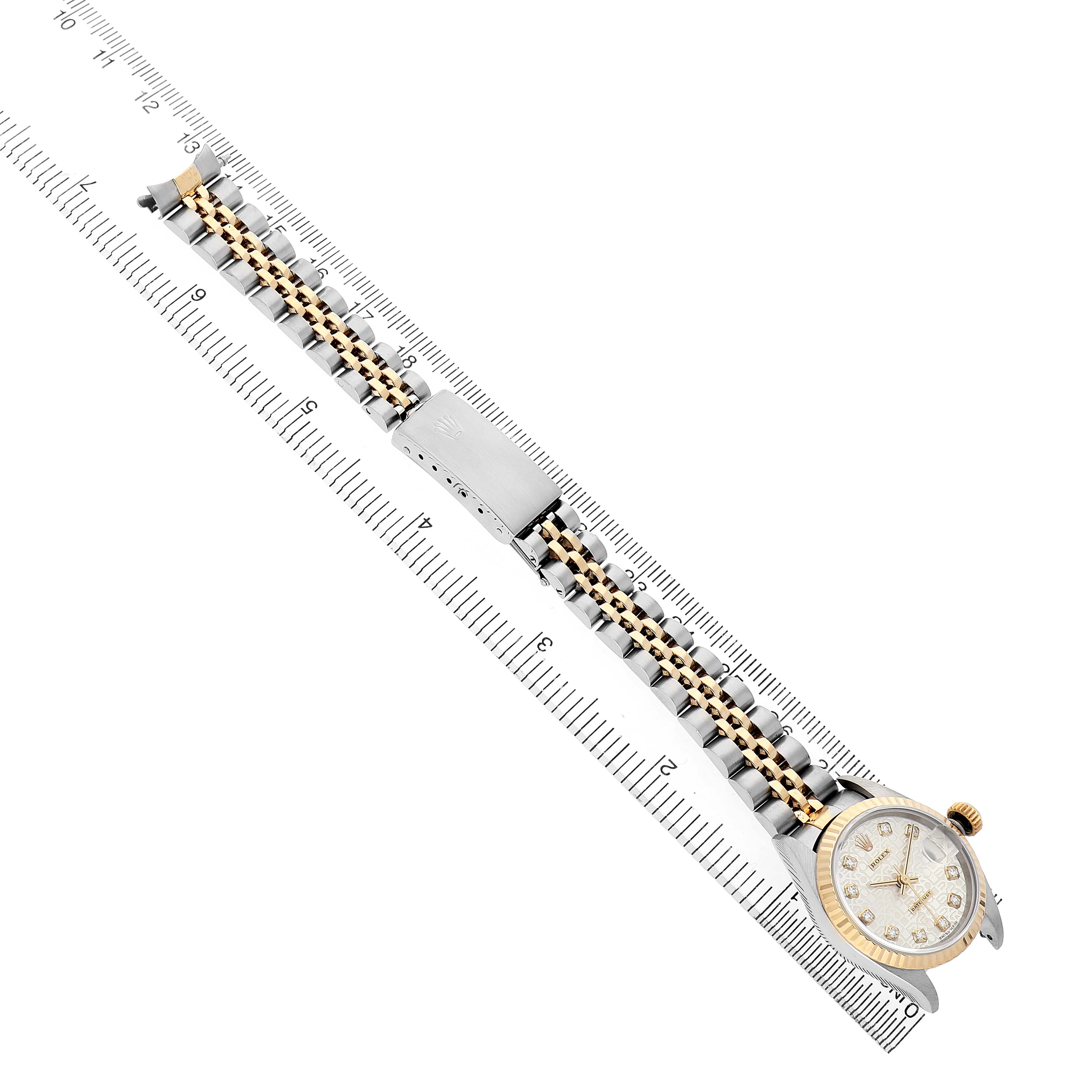 The Rolex Datejust 69173 Women's Steel and Gold (two tone) Silver Dial watch is shown from a top-down angle, featuring its face, bezel, and metal bracelet against a ruler.