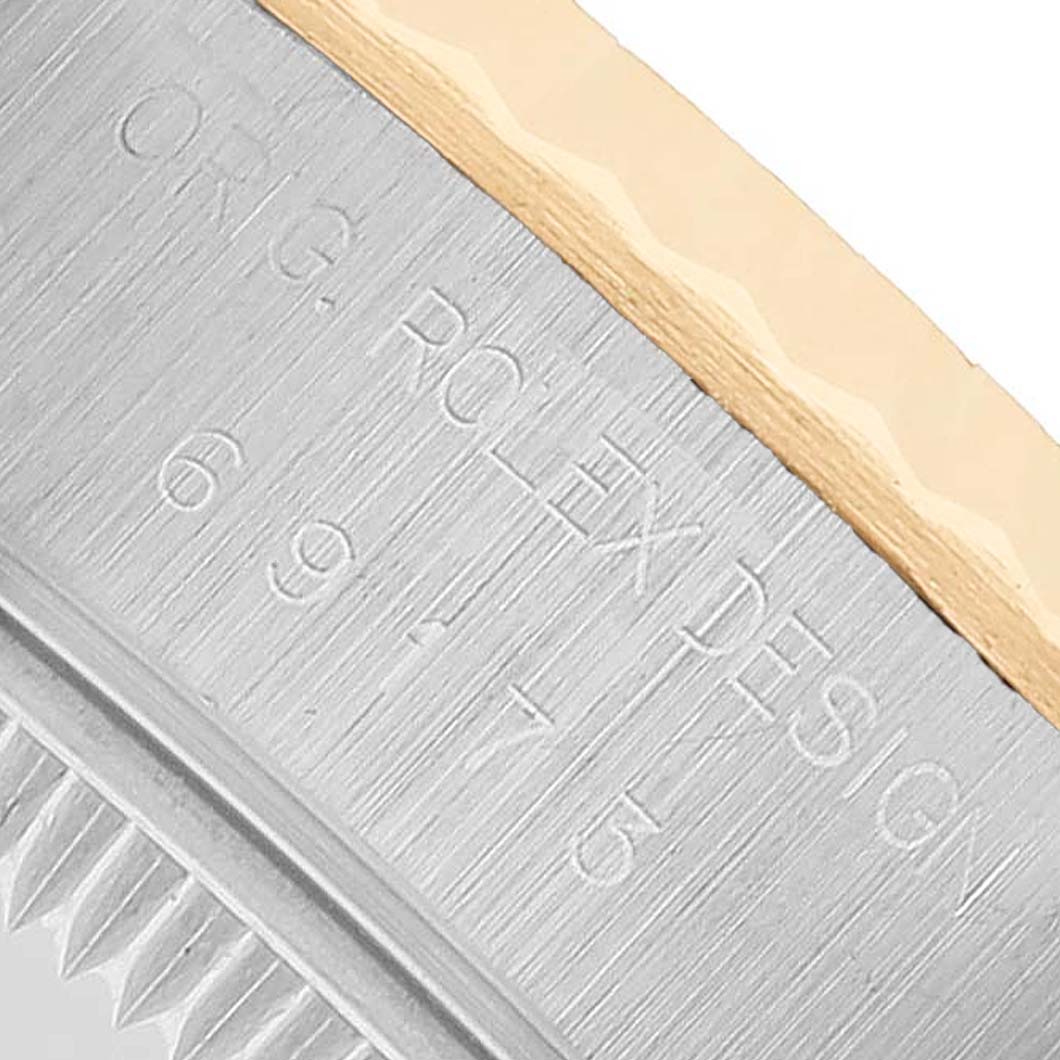 The image shows a close-up of the engraved case side and bezel of a Rolex Datejust 69173 Women's Steel and Gold (two tone) Silver Dial watch.