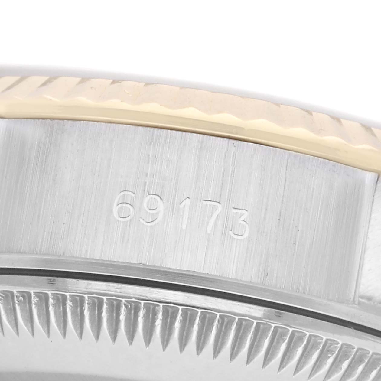 The image shows a close-up of the side of a Rolex Datejust 69173 Women's Steel and Gold (two tone) White Dial 69173 Women's Steel and Gold (two tone) White Dial watch, focusing on the bezel and engraved serial number.