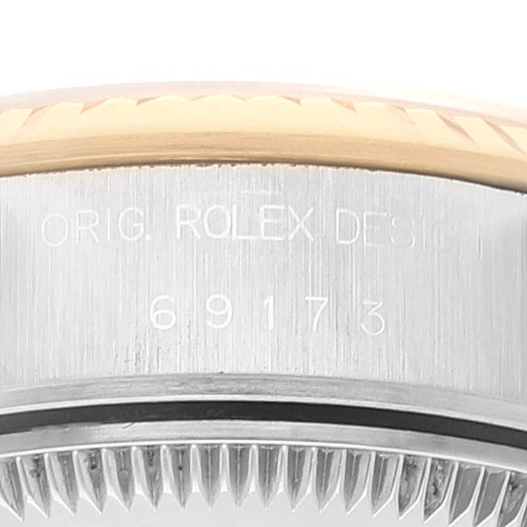 This close-up image of a Rolex Datejust 69173 Women
s Steel and Gold (two tone) White Dial 69173 Women
s Steel and Gold (two tone) White Dial watch shows the case side with engravings.