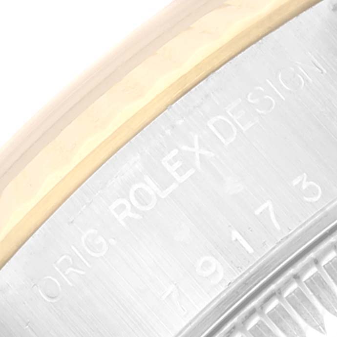 This close-up image shows the engraved serial number and part of the bezel on a Rolex Datejust 79173 Women's Steel and Gold (two tone) White Dial 79173 Women's Steel and Gold (two tone) White Dial watch.